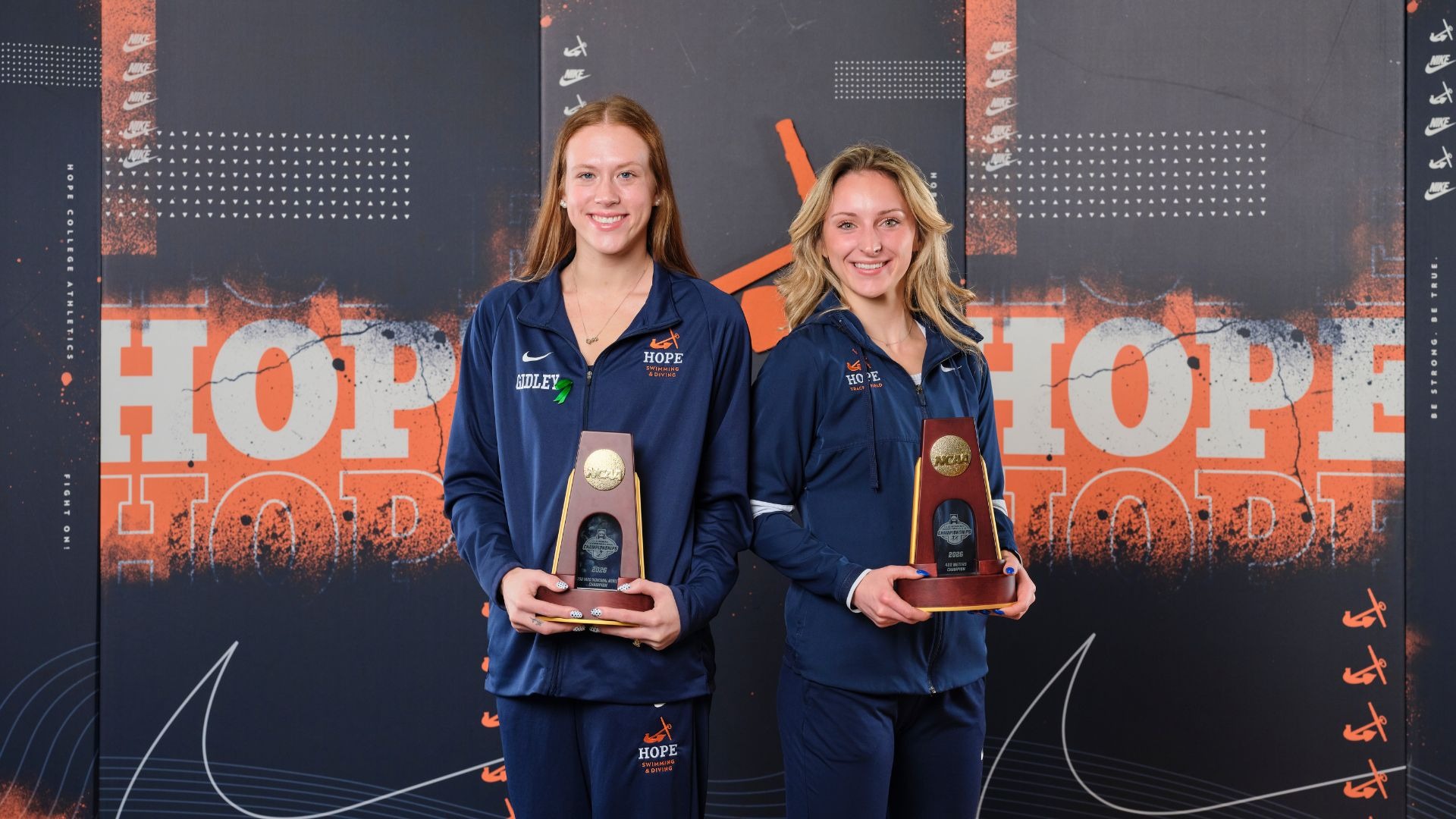 Greta Gidley and Sara Schermerhorn hold their NCAA Championship trophies.