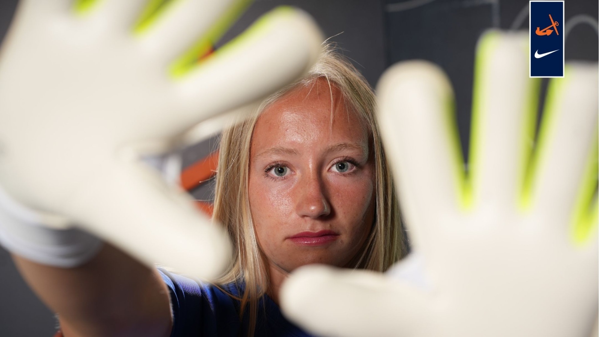 Goalkeeper Clara Feenstra holds her gloves in front of her face.