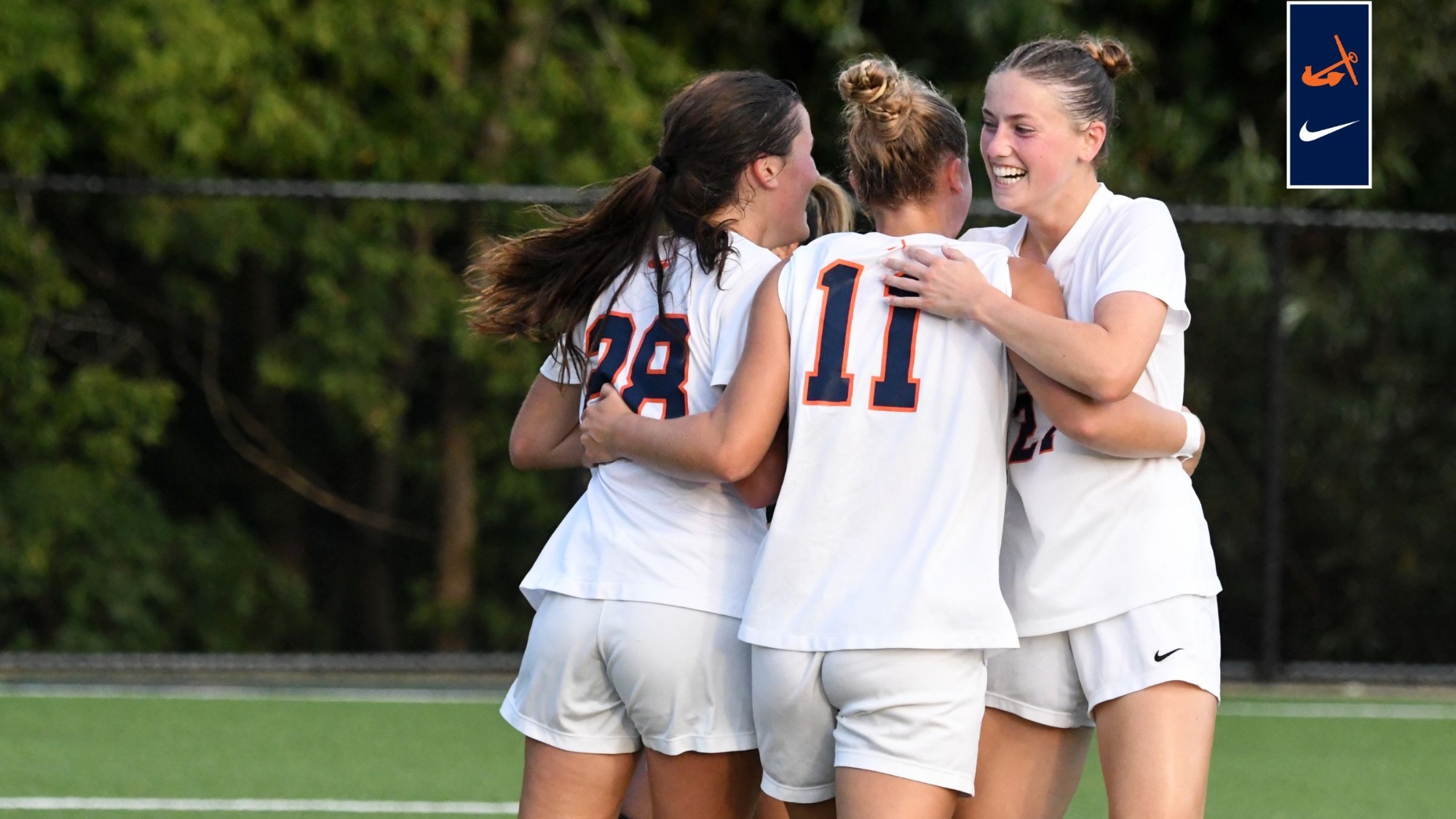 Three Hope College women's soccer teammates huddle as they celebrate a goa.