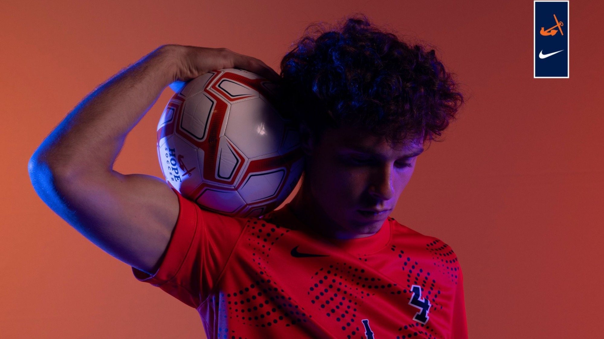 Seth Walters holds a soccer ball on his shoulder.