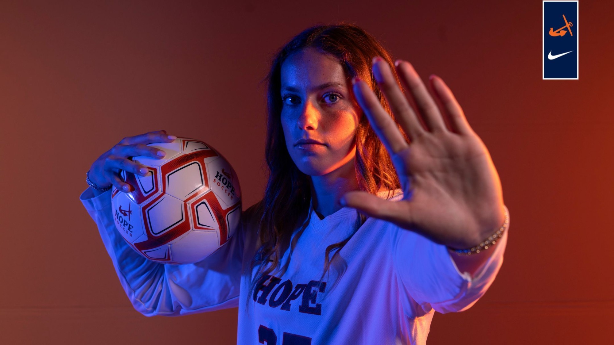 Halle Barnard holds a soccer ball in her right hand.