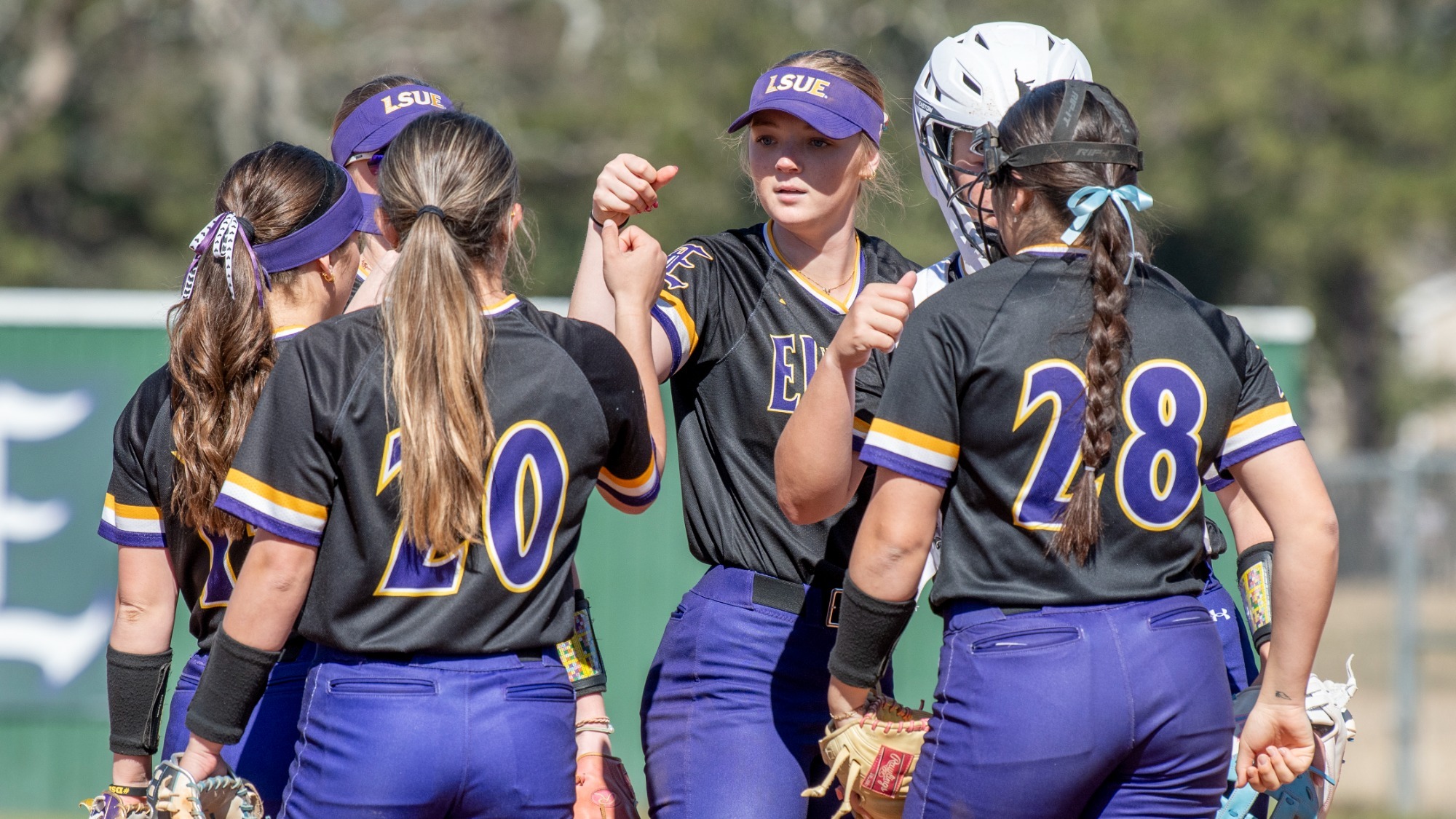 Jordan Stanley among others meet in the pitching circle during a recent game.