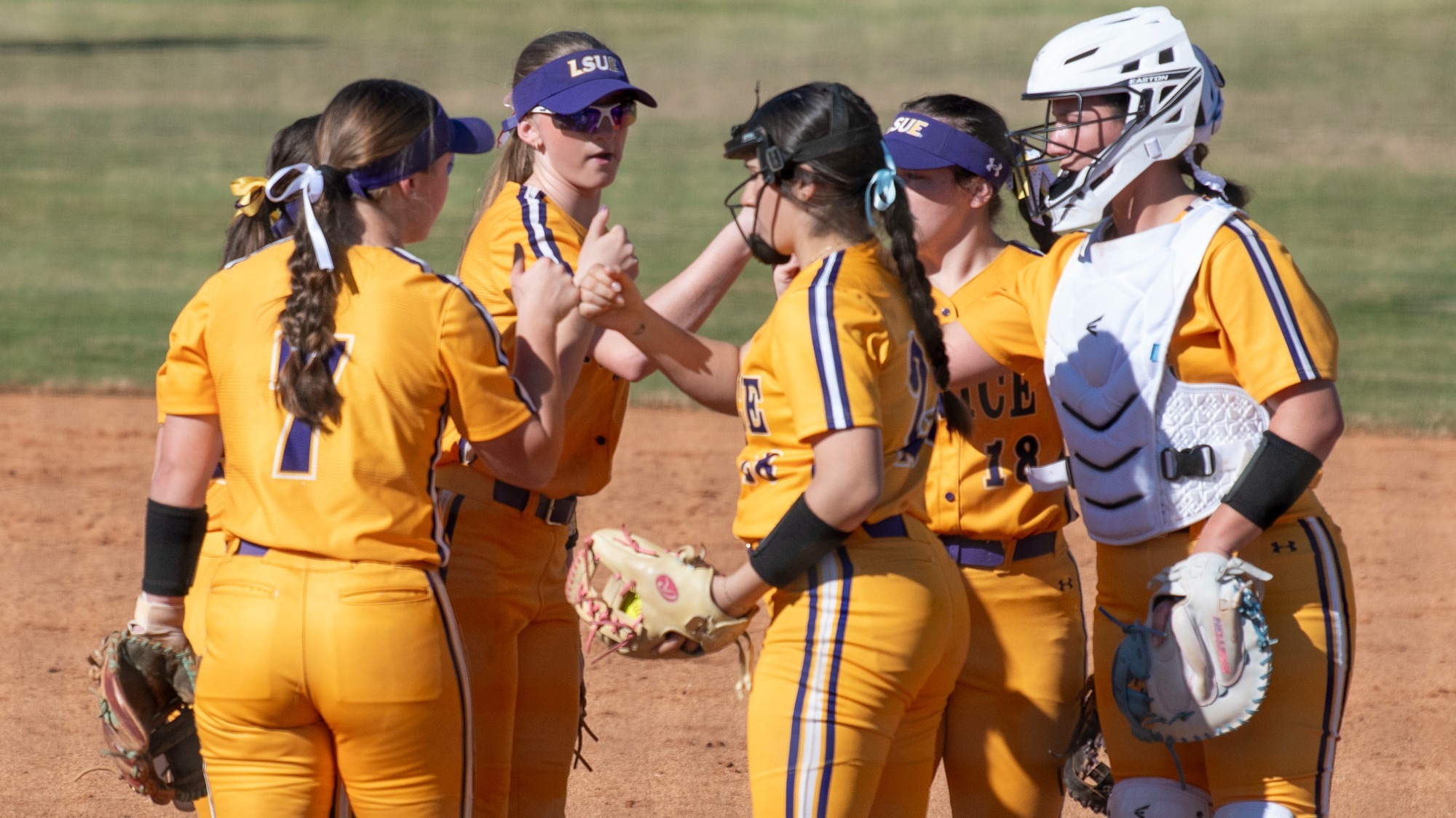 The LSUE infield meets in the pitching circle in action at Lady Bengal Field.
