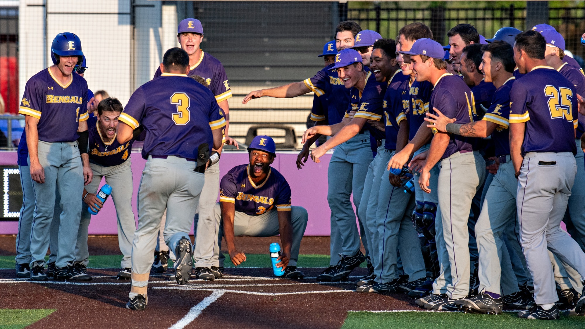Jordan Luna is met by his teammates at home plate after hitting a game winning home run.