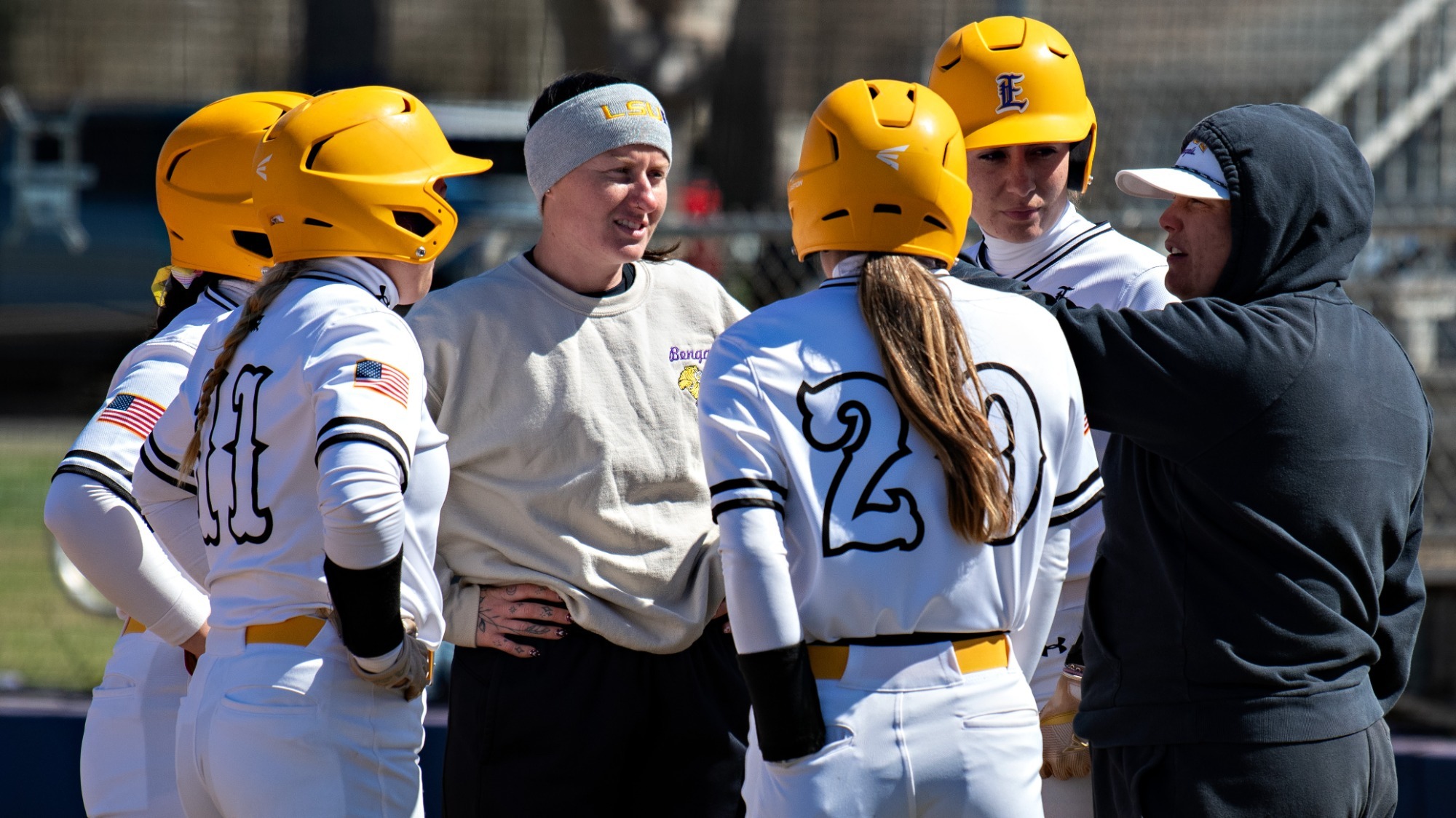 The softball team discusses an offensive situation during a recent home game.