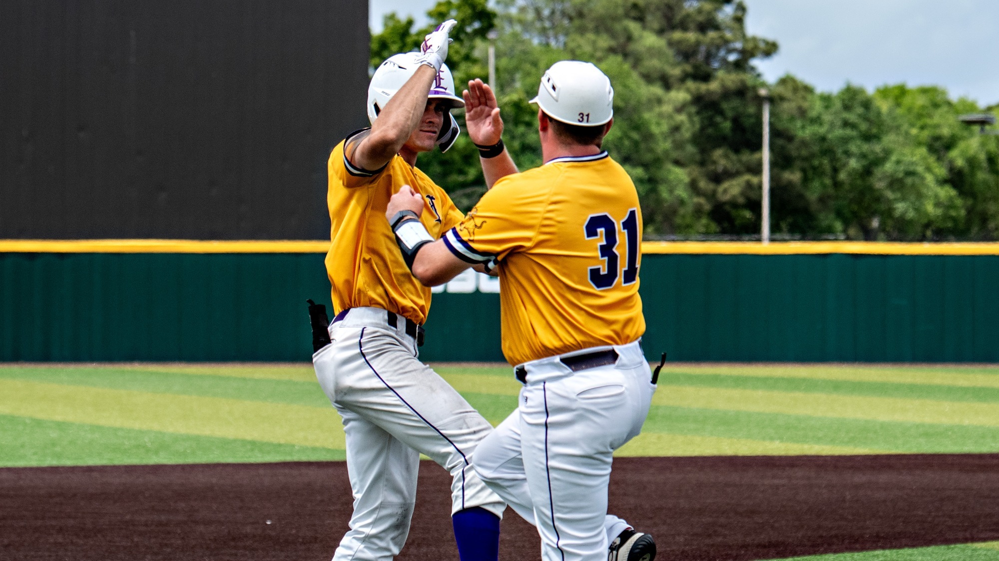 Aidan Mouton celebrates a home run with assistant Nick Studdard.