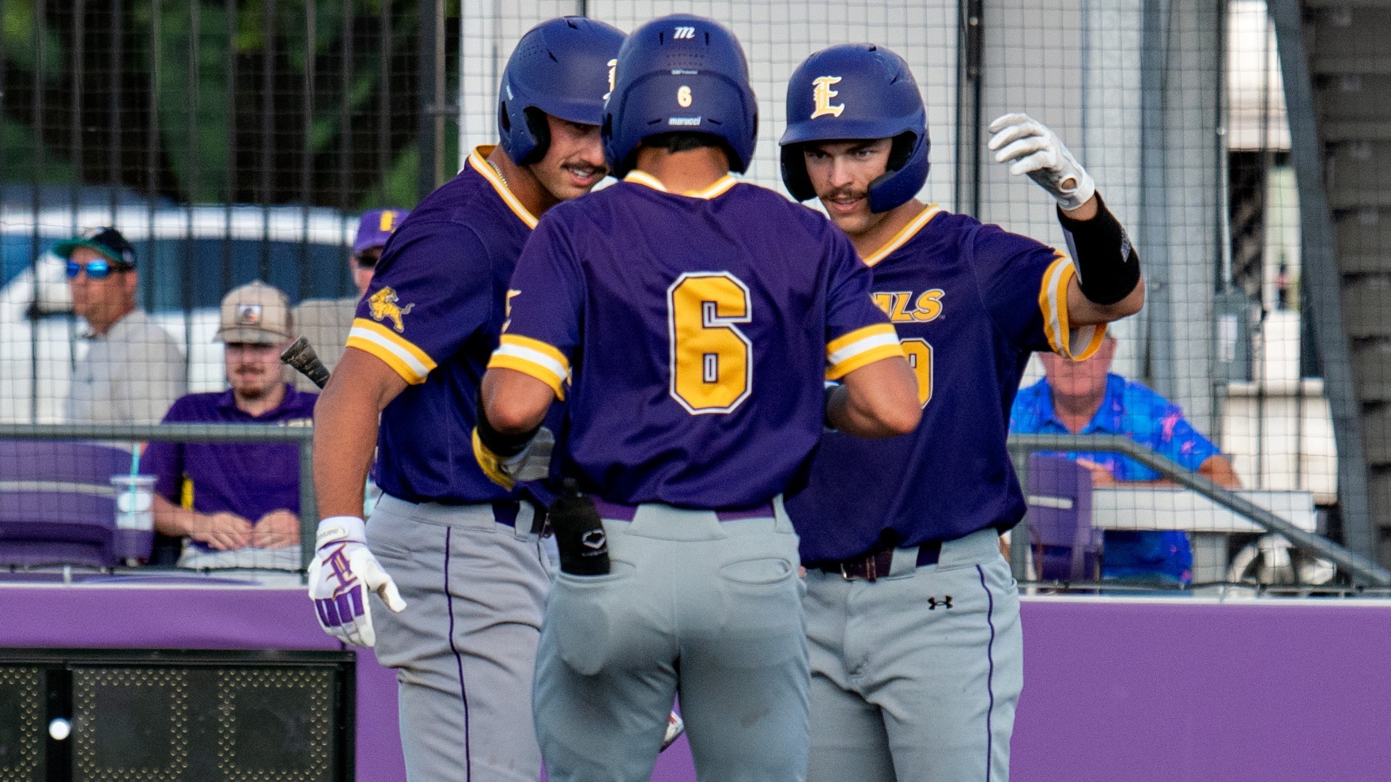Tyler Mitchell is met at home plate by teammates after hitting a home run.