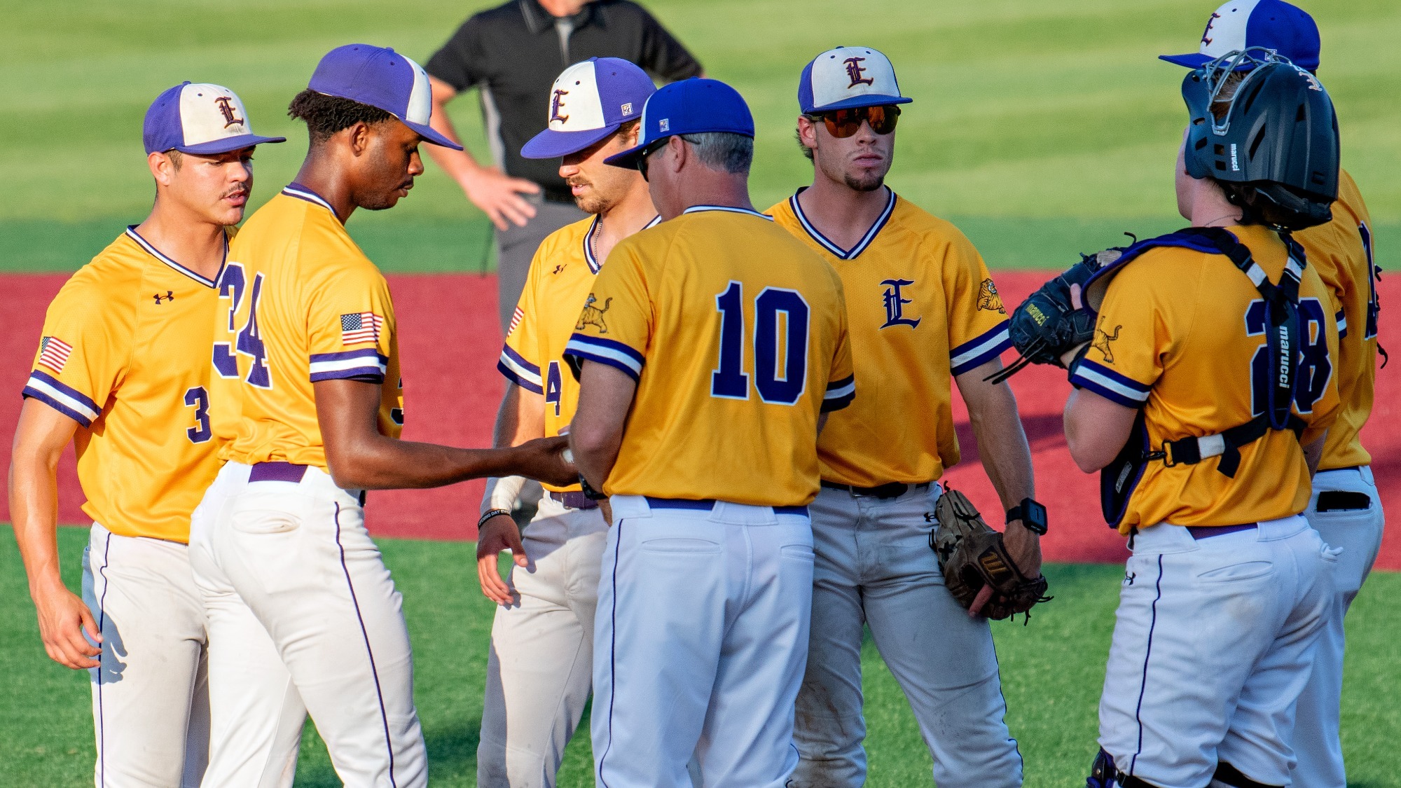 Jeff Willis gives the ball to Xavier Woods during a pitching change.