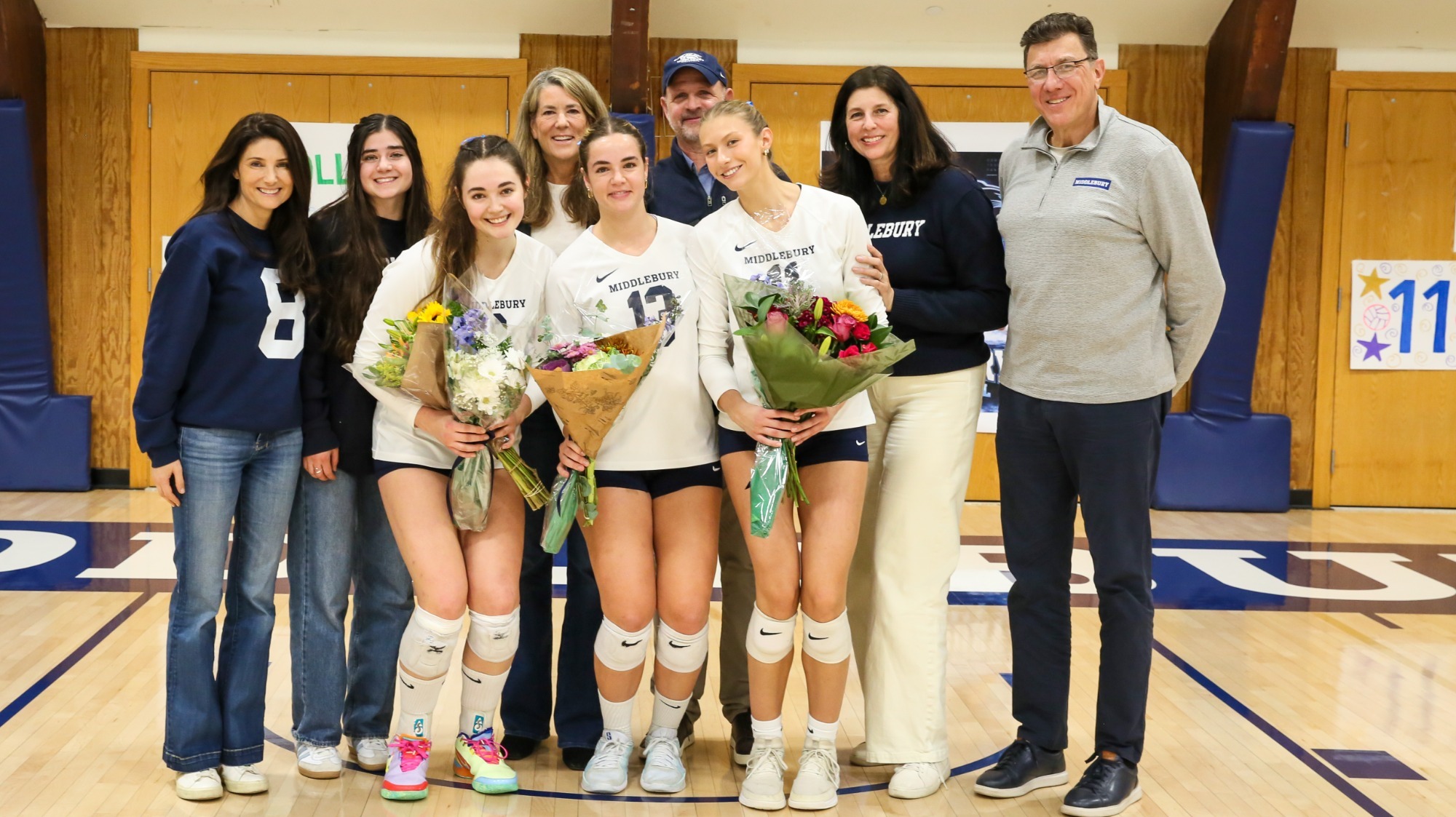 Middlebury's seniors Molly Harrison, Sophie Horn and Gabby Pribisich pose with their families during their senior day celebration against Connecticut College.
