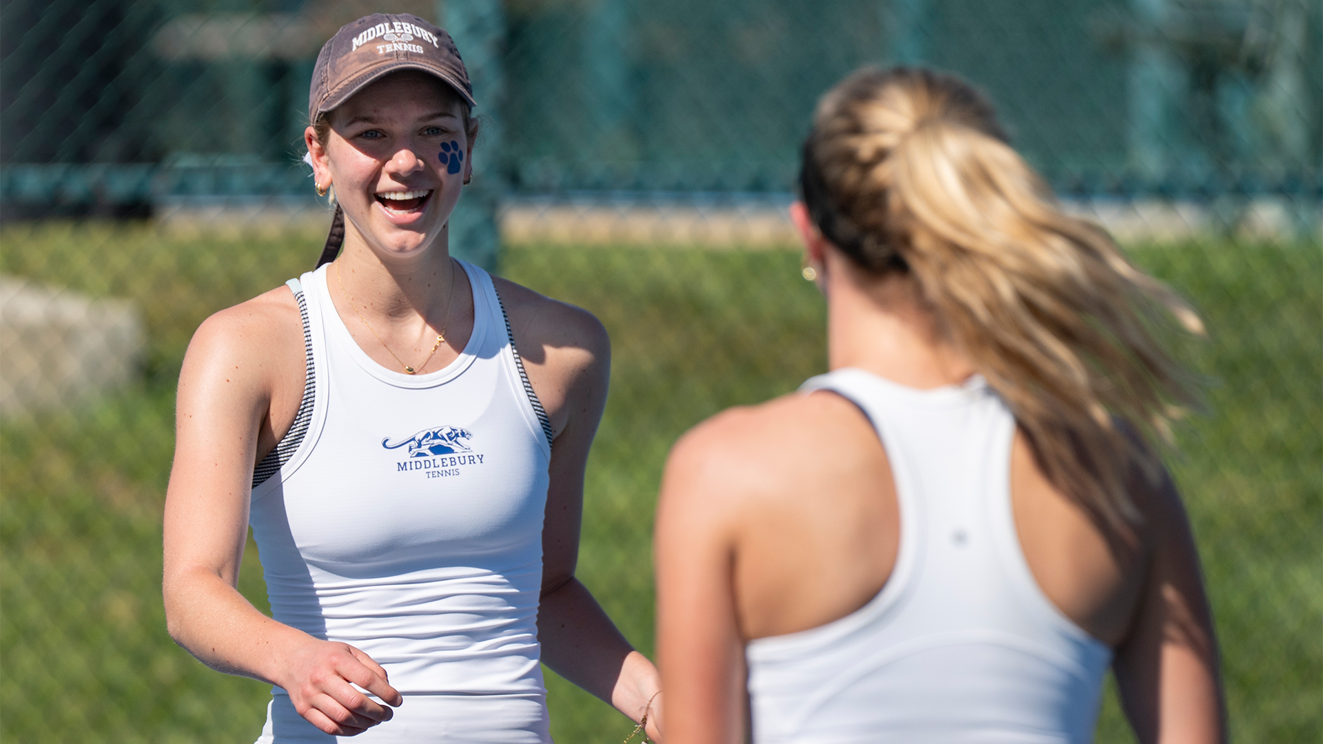 Elsie Van Wieren celebrates with Anna Lardner after winning a doubles point against Pomona-Pitzer.