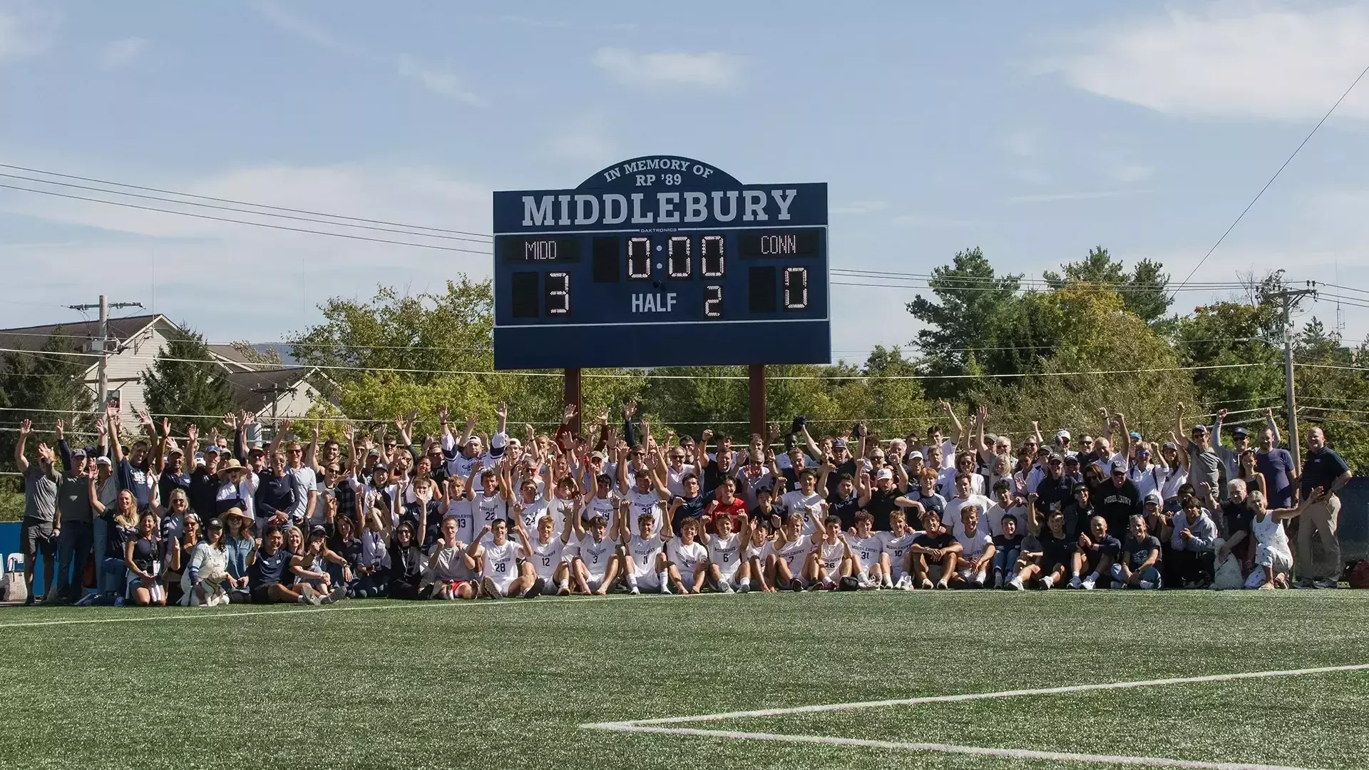 The Middlebury men's soccer team poses for a photo with its new scoreboard after a 3-0 victory over Conn. College.