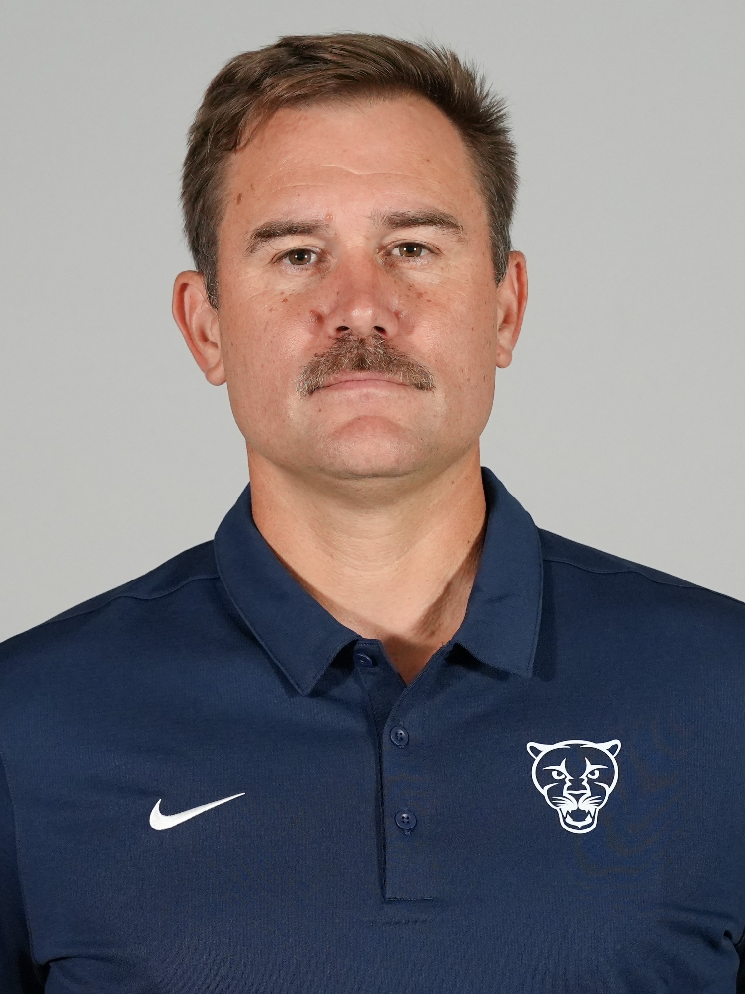 A headshot of Middlebury football coach Gus Brakeley.