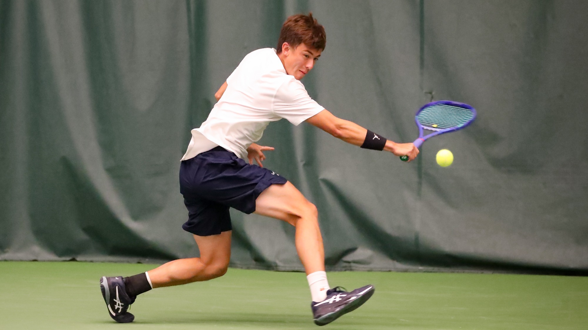 Noah Lewis attempts to return a shot during the 2026 ITA Regionals.