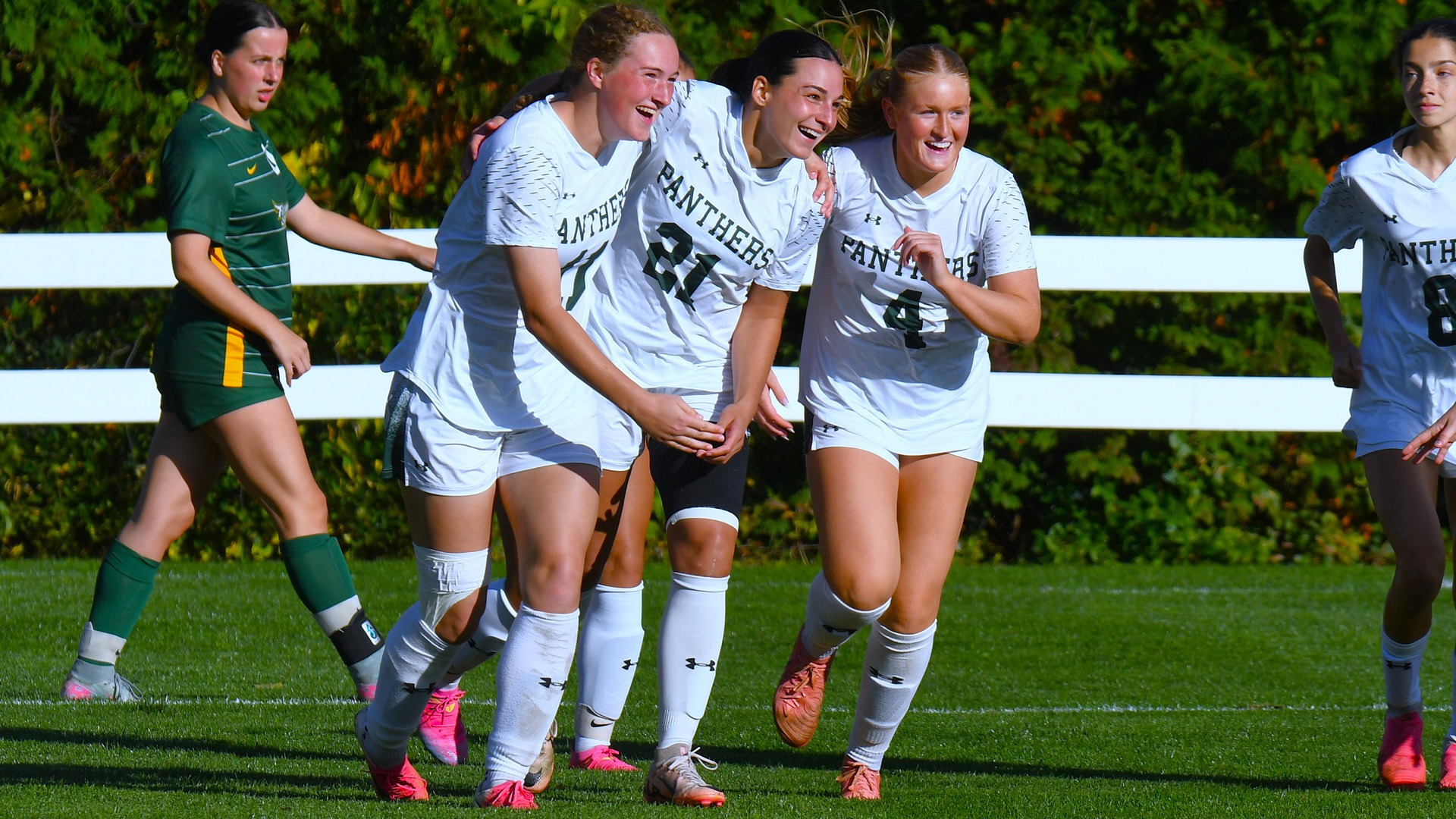 Maggie MacDonald, Piper Sullivan and Islah Godo celebrate MacDonald's goal against Fitchburg State