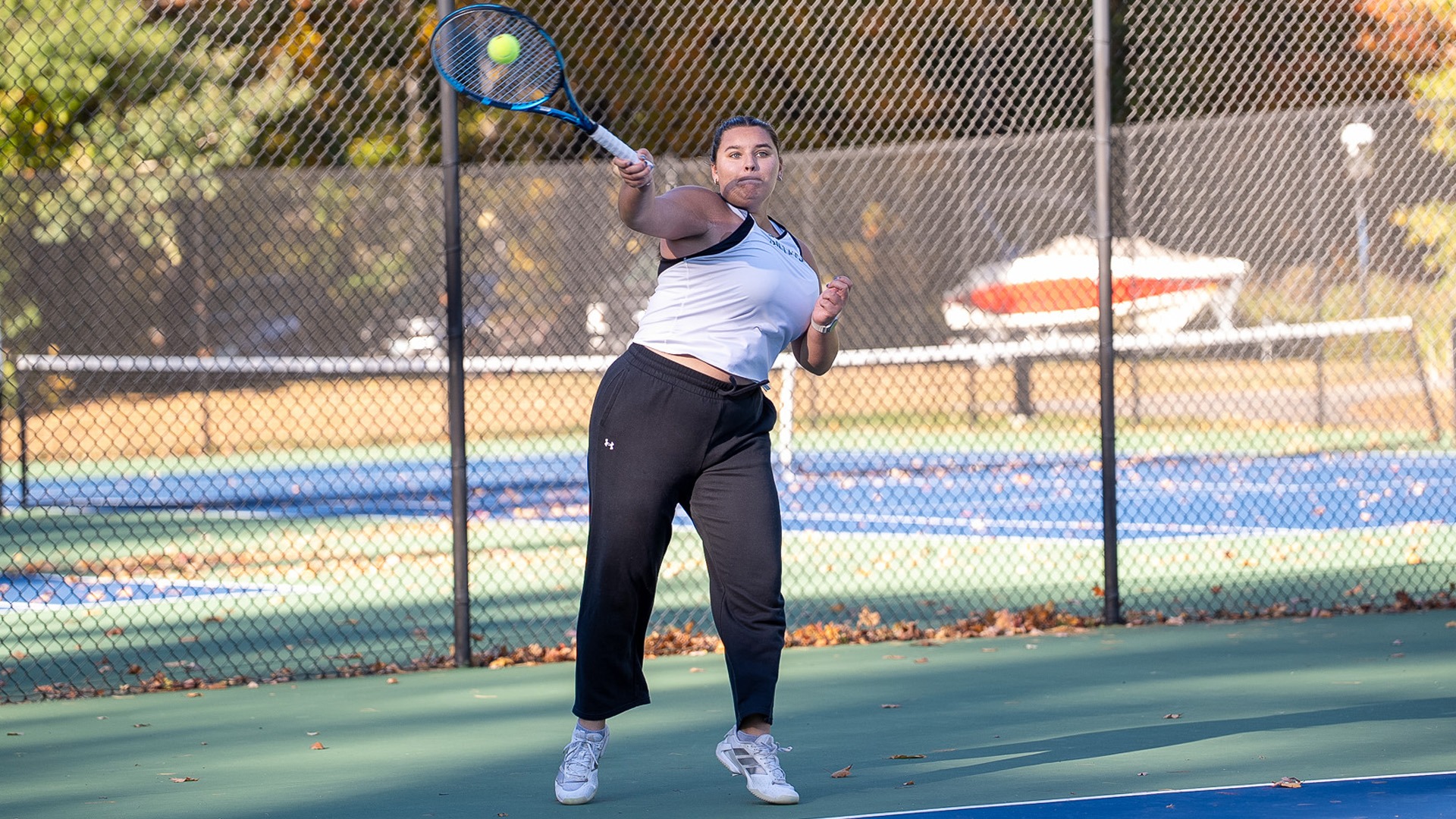 Sidney Huff smashes a forehand against Rhode Island College