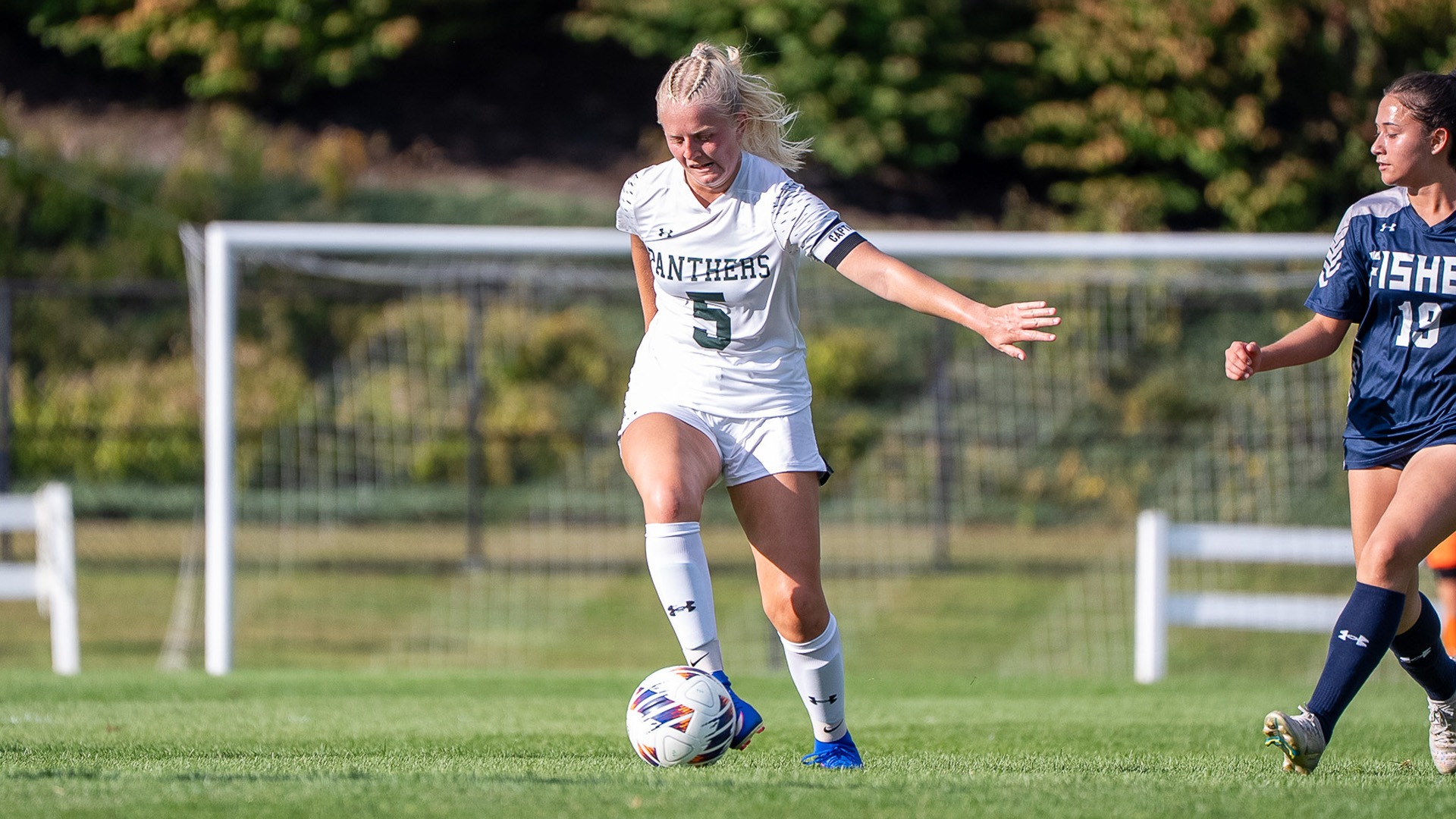 Clara Wilson dribbles past a Fisher athlete