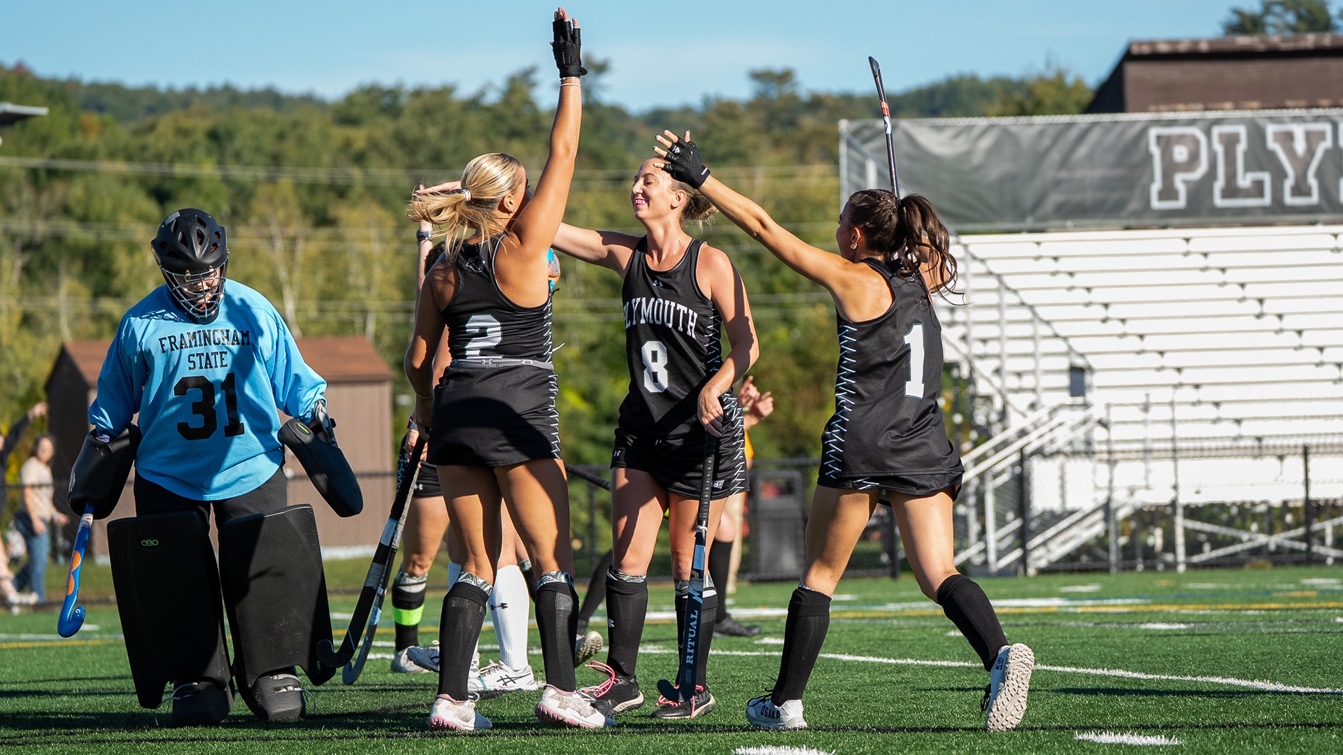 Georgia Coleman (2), Lexi Berrettini (8) and Amelia Avery (1) celebrate after a goal against Framingham State