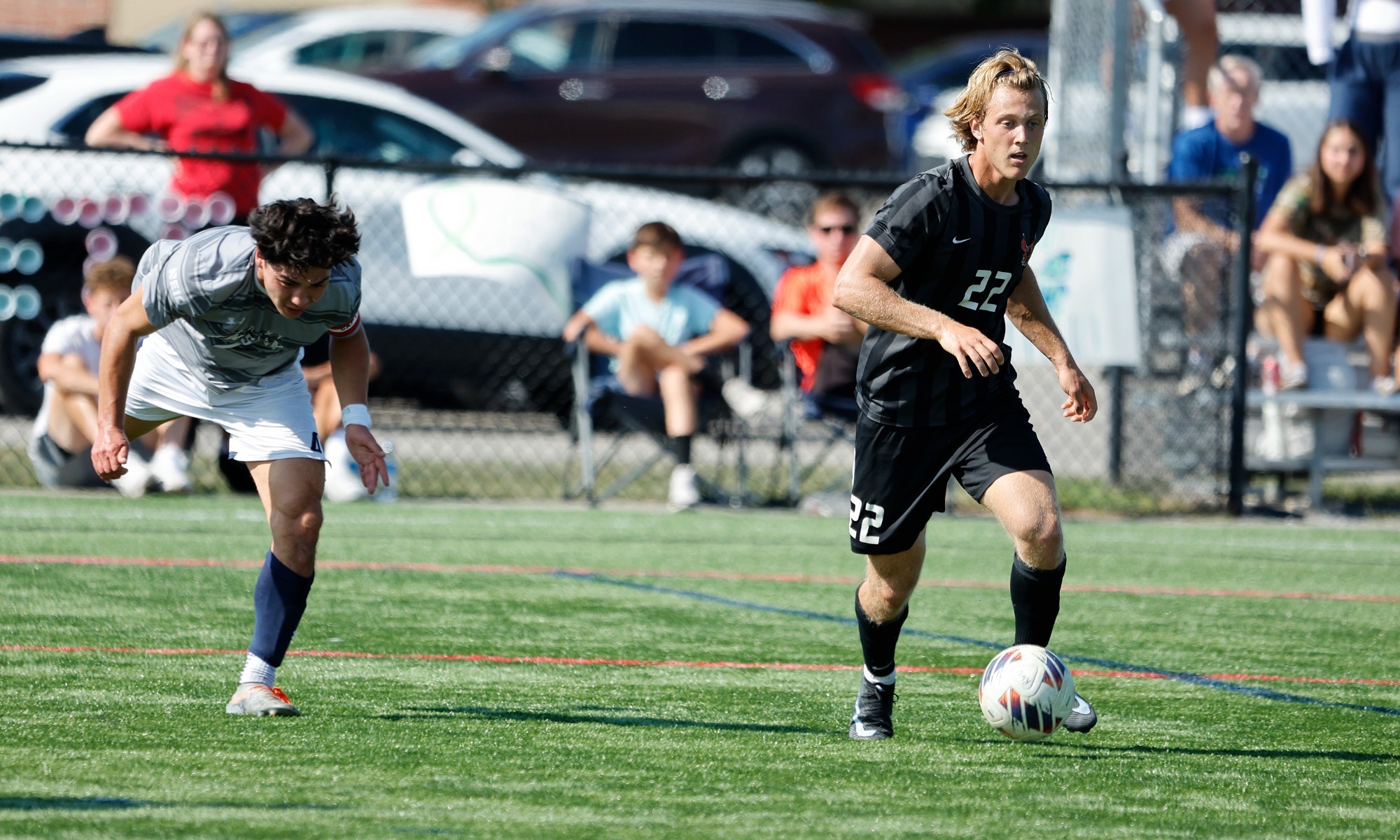 Luke Hanes dribbles the ball against Saint Anselm in an early season match