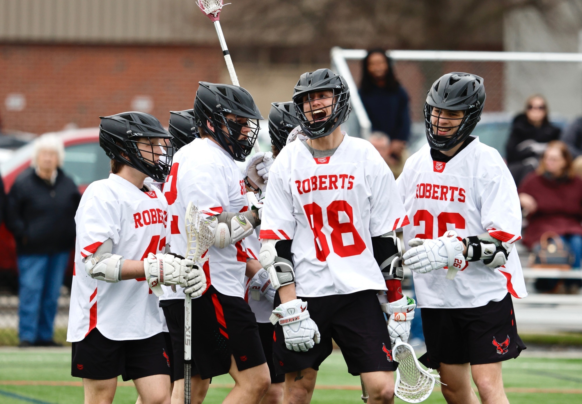 Members of the Roberts Wesleyan University men's lacrosse team celebrate after scoring a goal against Lake Erie College on March 25, 2026.
