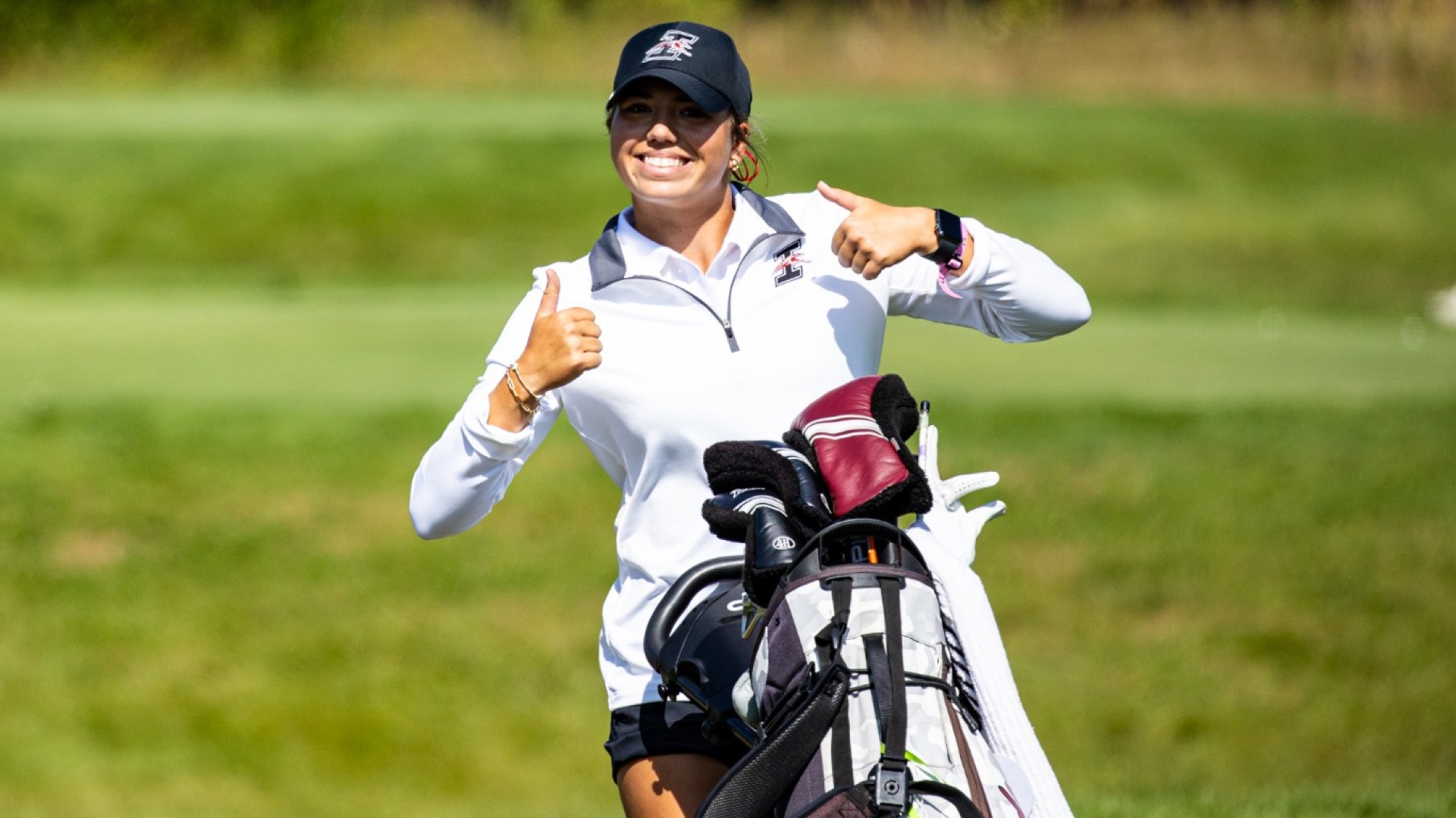 Macy Brown giving a thumbs up to the camera while on the course.