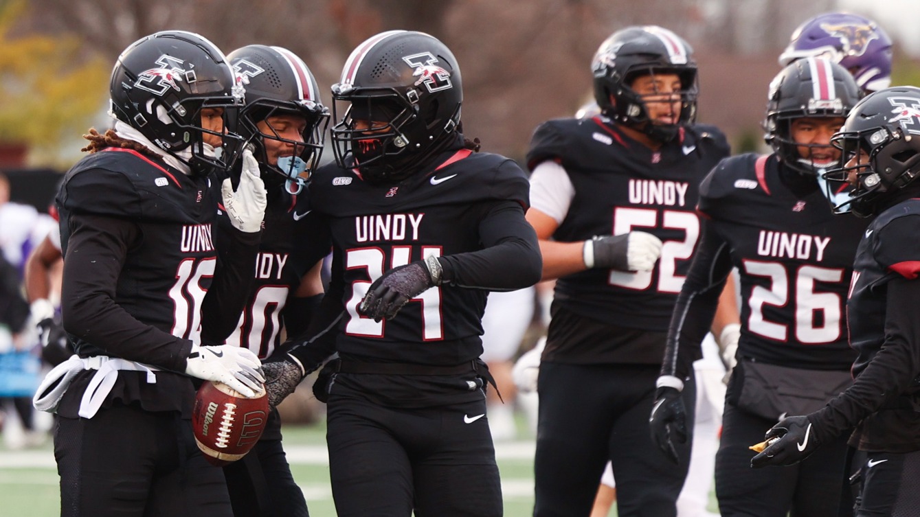 UIndy defense runs off the field with the ball.