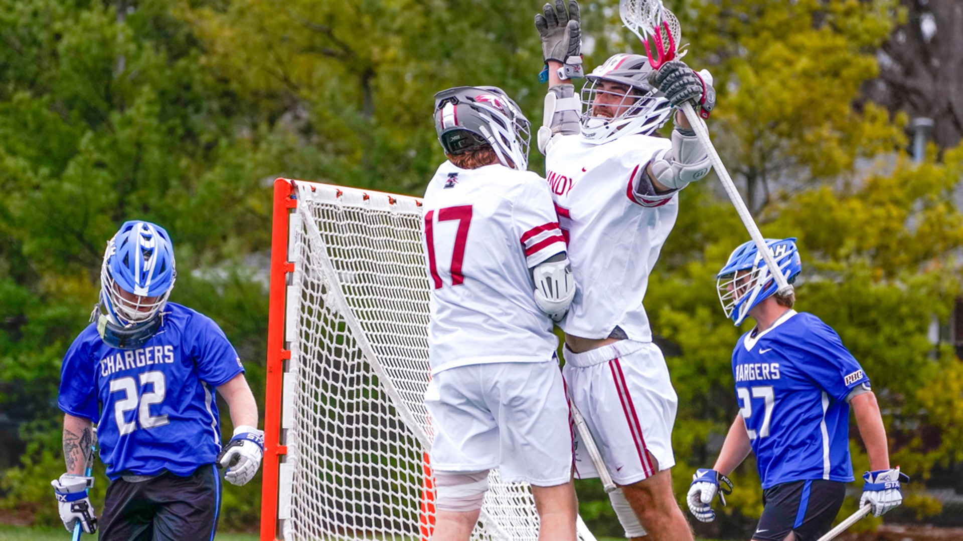Matt Pereira chest bumps Mason Rockley after scoring a goal on Saturday. A pair of UAH defenders bookend the celebration with their heads facing the ground.
