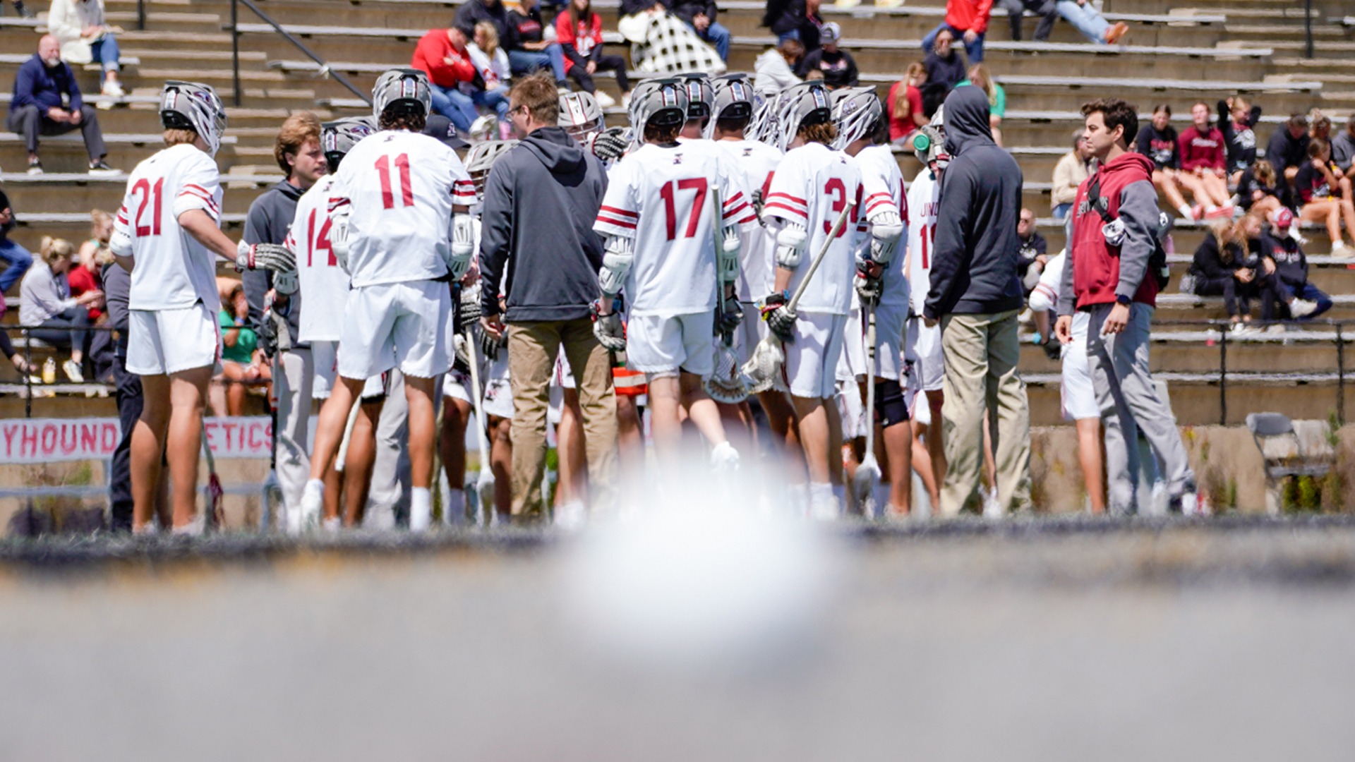 Men's Lacrosse team with a faded ball in the foreground.