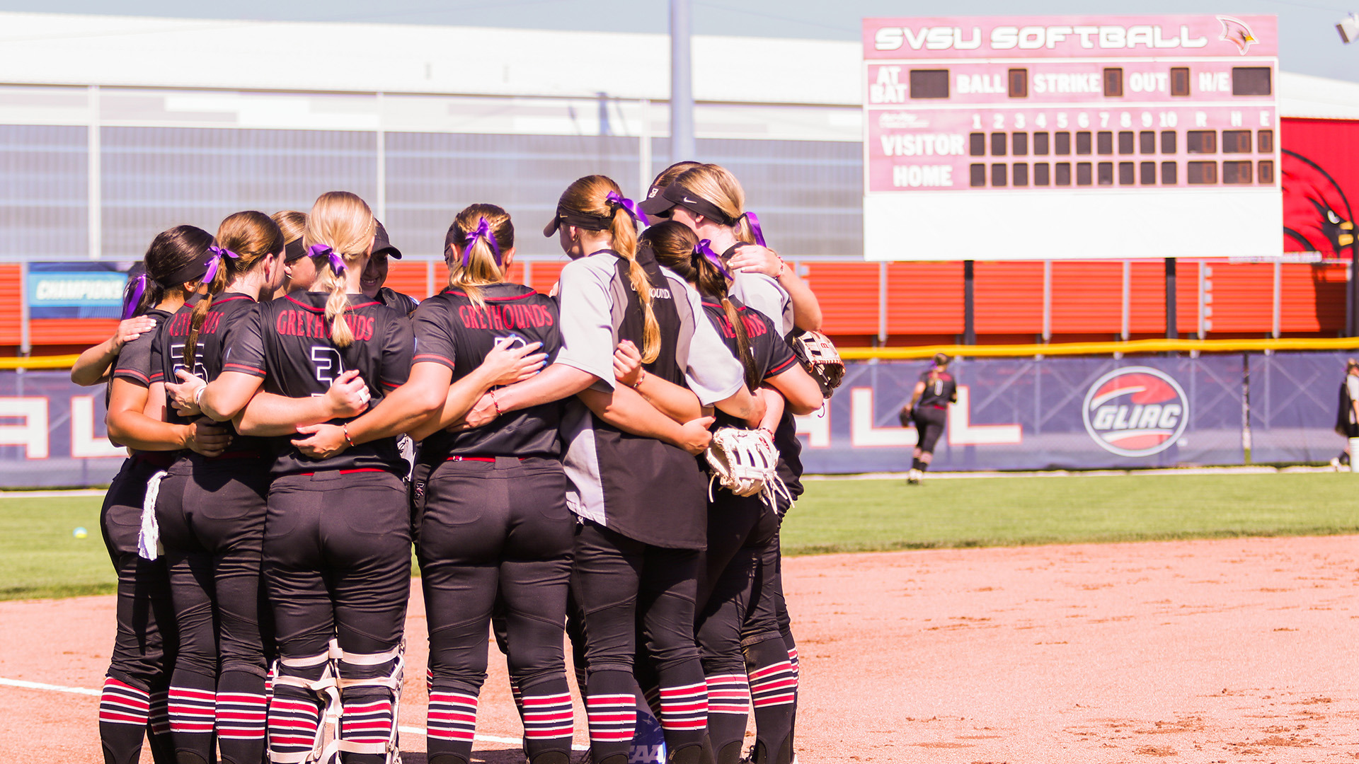 The UIndy softball team infield huddle together before the game.