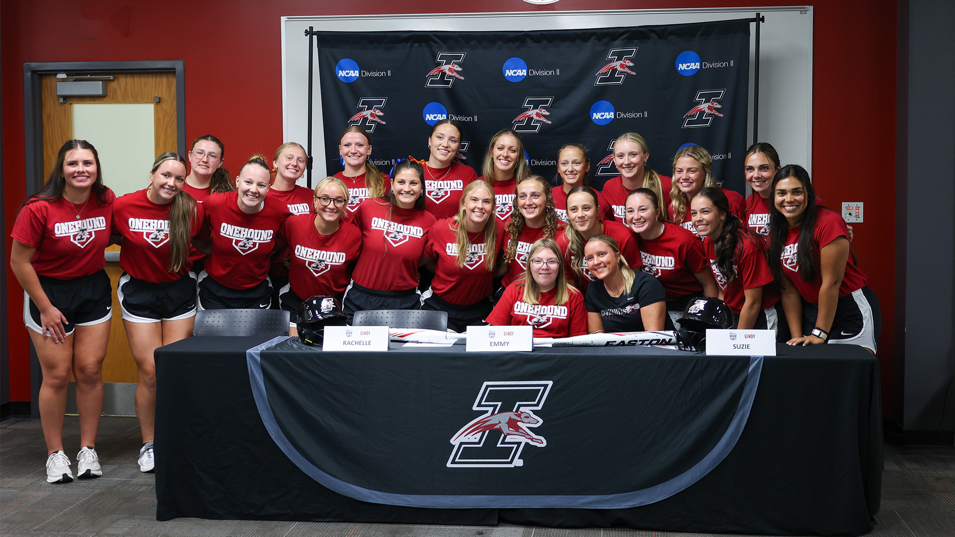 The UIndy softball team posing with Emmy Steele, its new Team IMPACT signee.