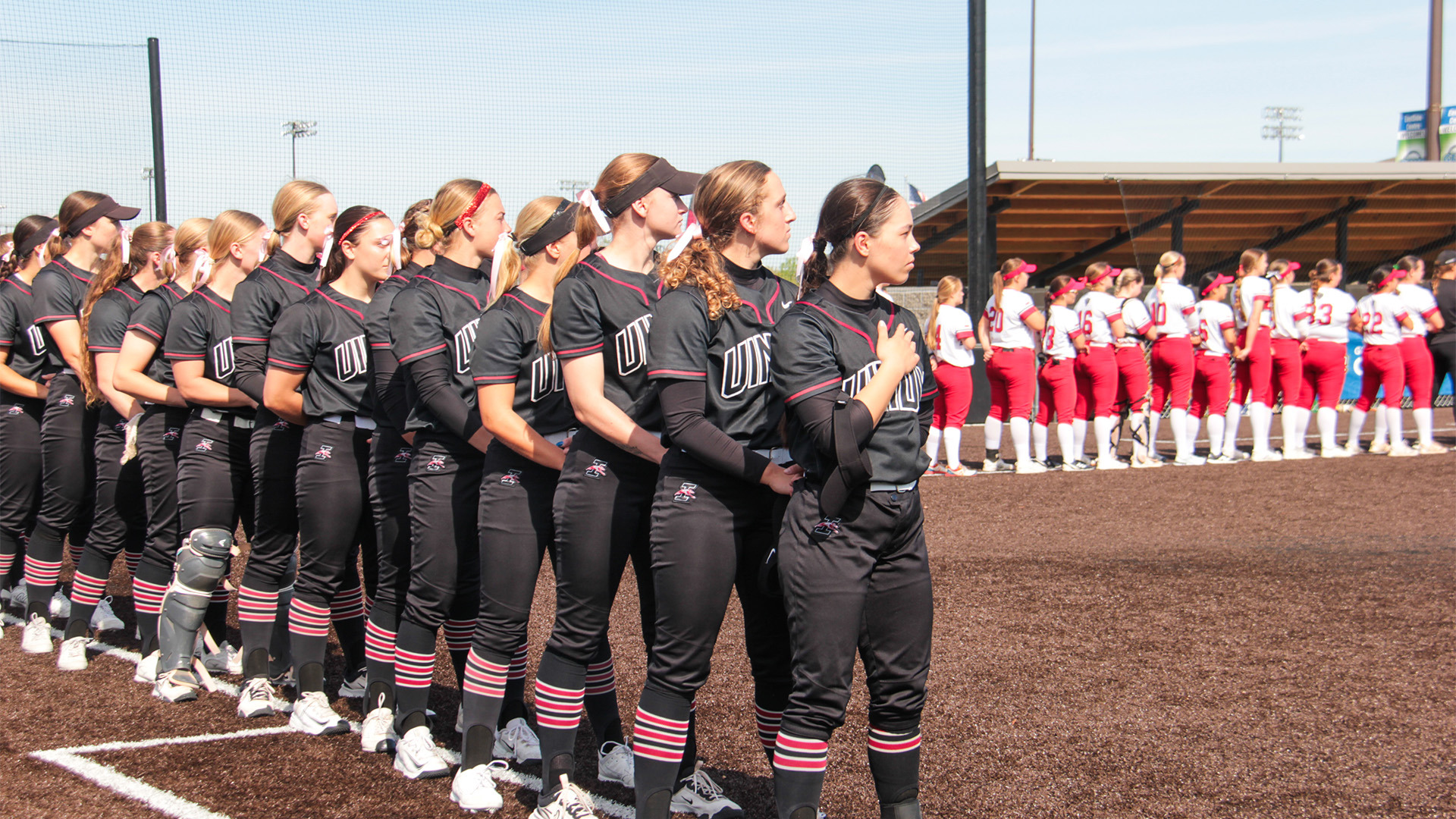 The UIndy softball team lined up down the first-base line for the national anthem.