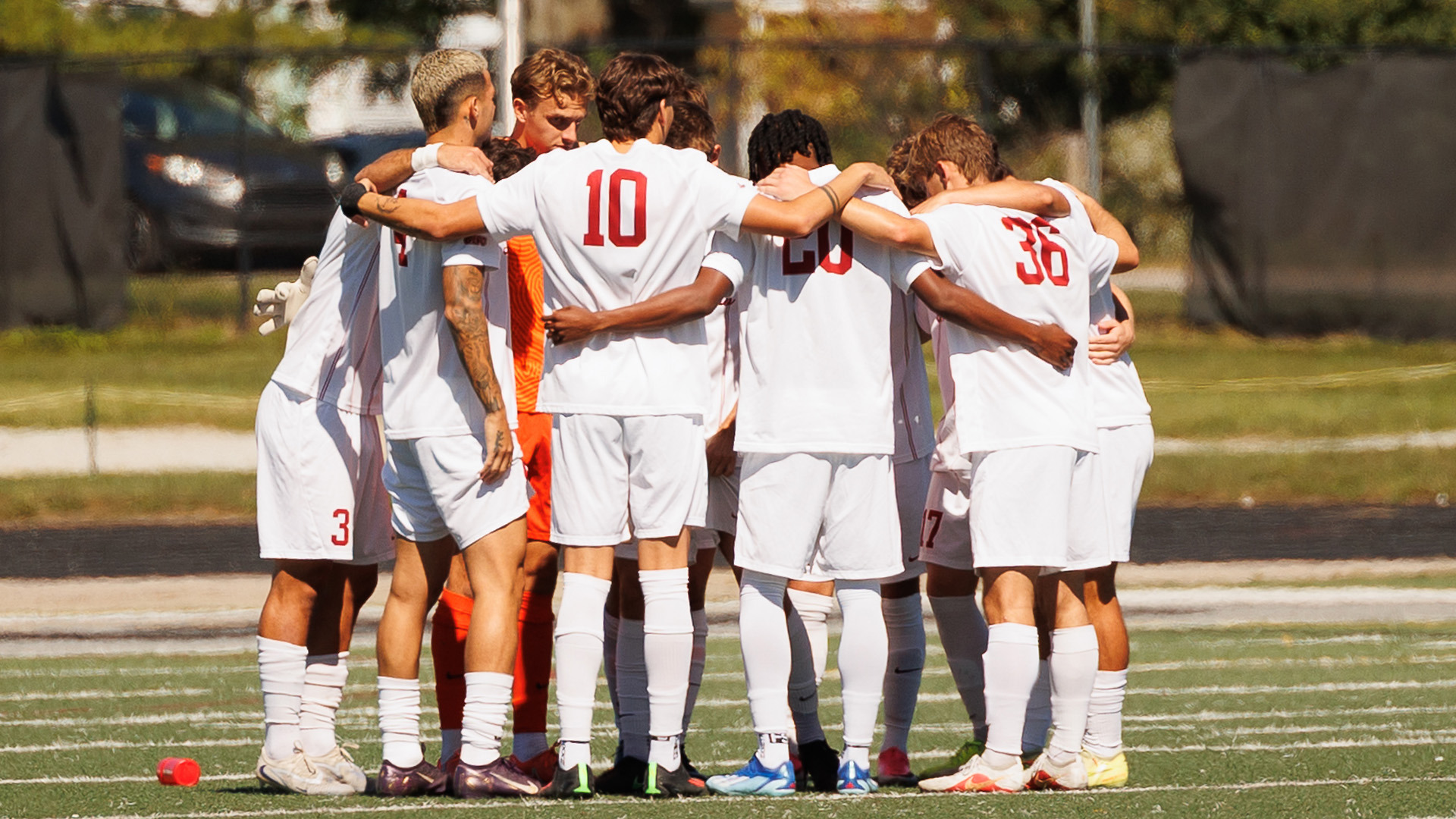 The UIndy men's soccer team huddling up prior to kickoff.
