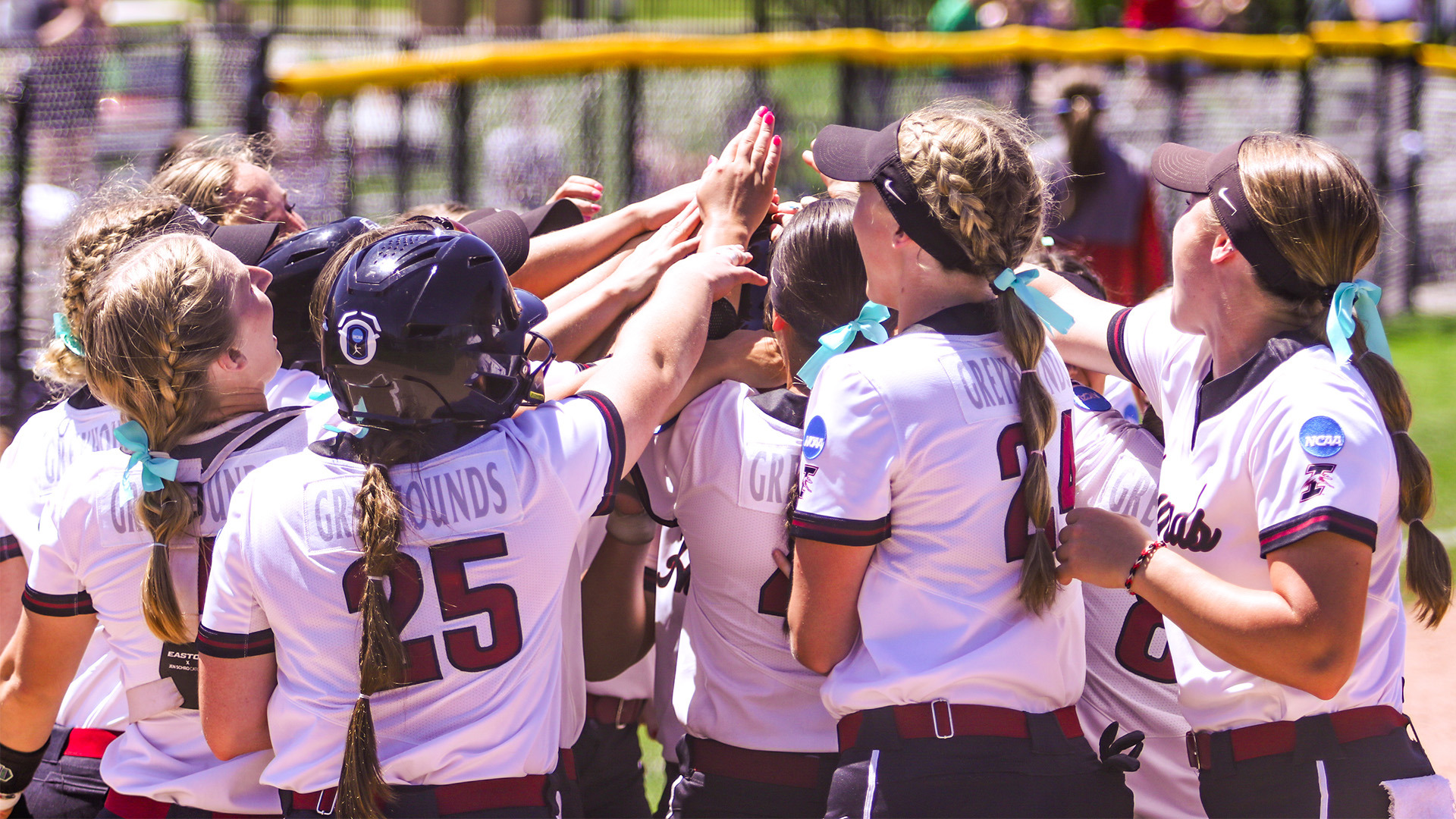 The UIndy softball team huddles up before a game.