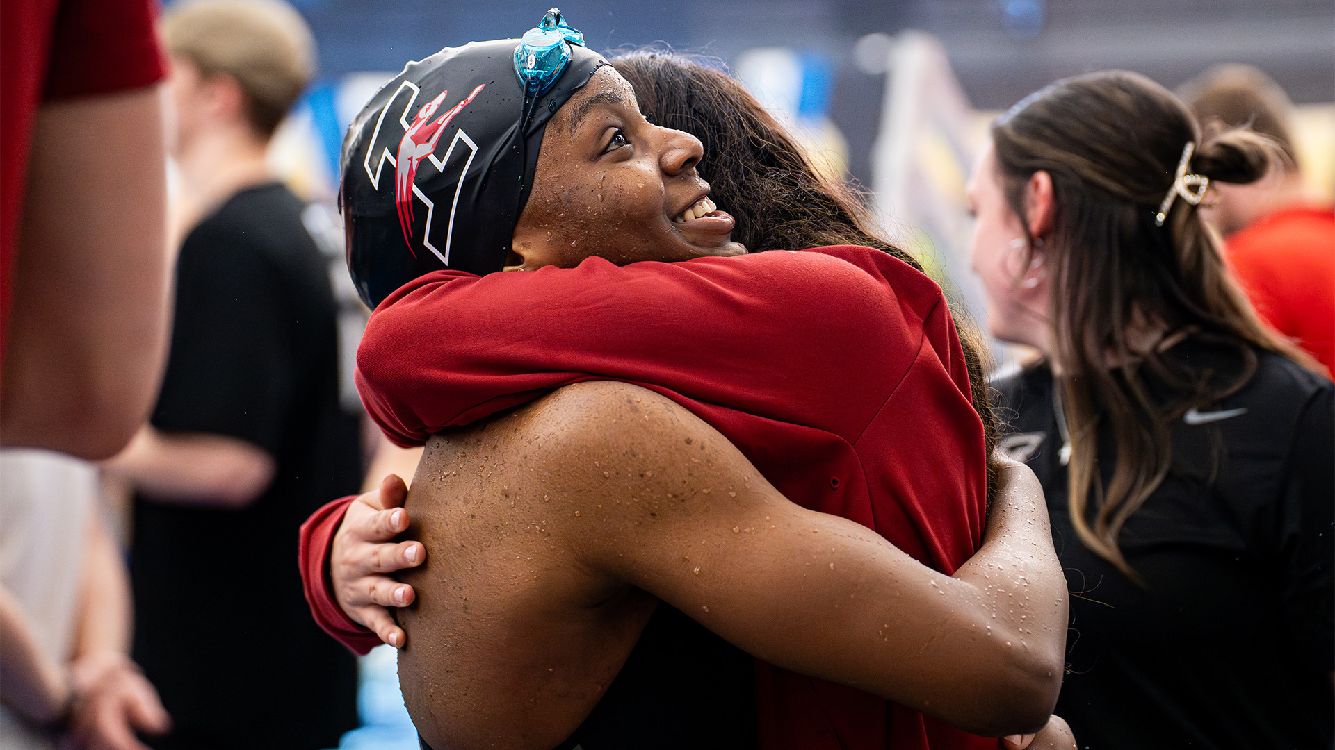 Kirabo Namutebi gets a hug from a teammate after her 50 free national championship win.