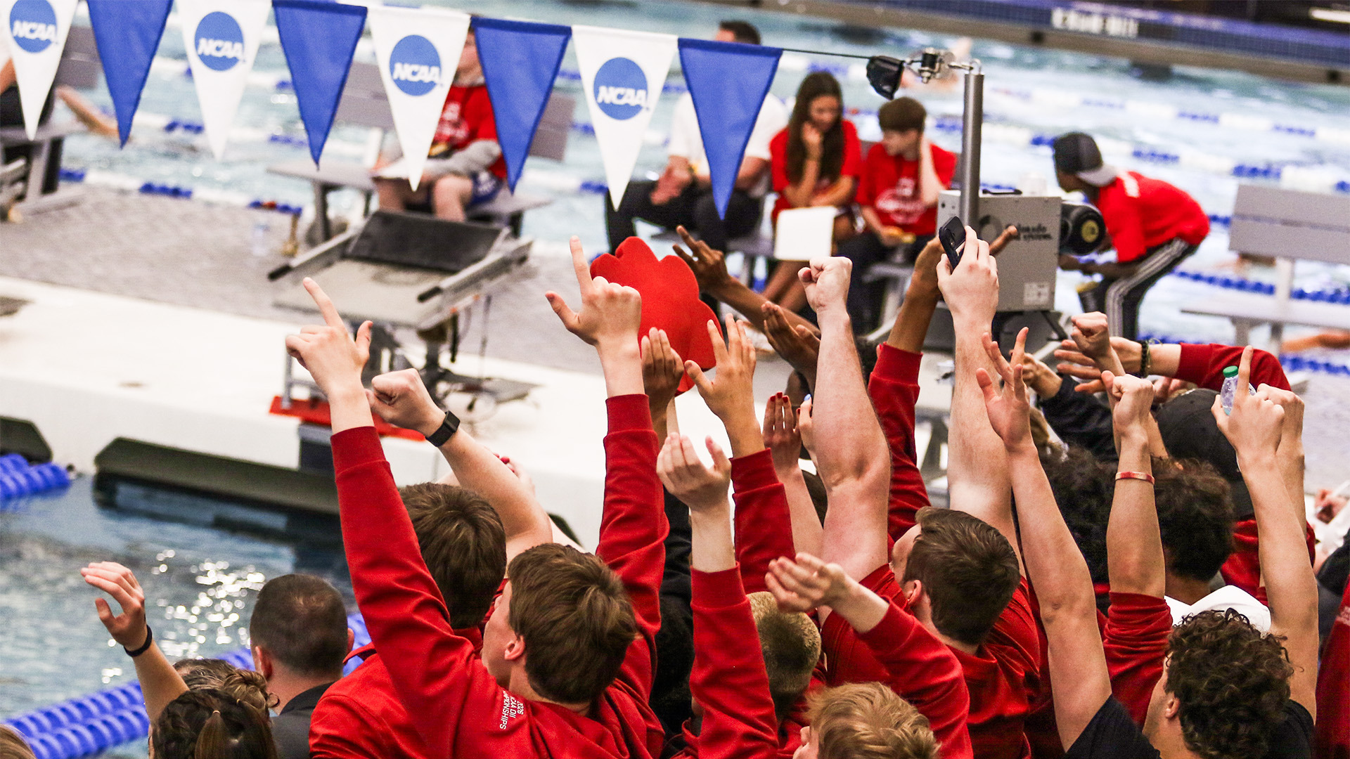 Members of the UIndy swimming and diving team cheer on their teammates at the 2026 NCAA DII Championships.