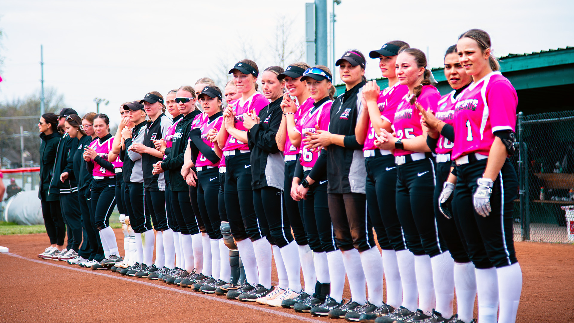 The UIndy softball team lined up on the first base line.