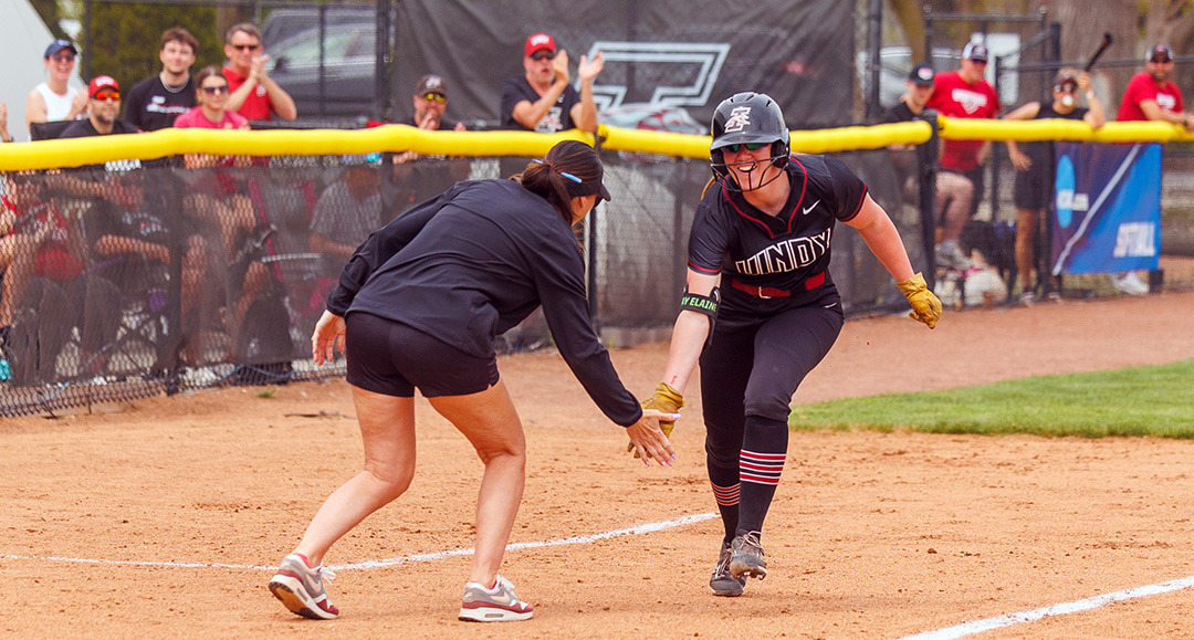 Caitlin Bunte low-fives Coach Frost as she rounds third base on her home run trot.