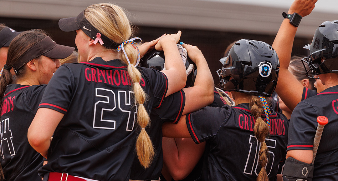 The UIndy softball team celebrating a home run.