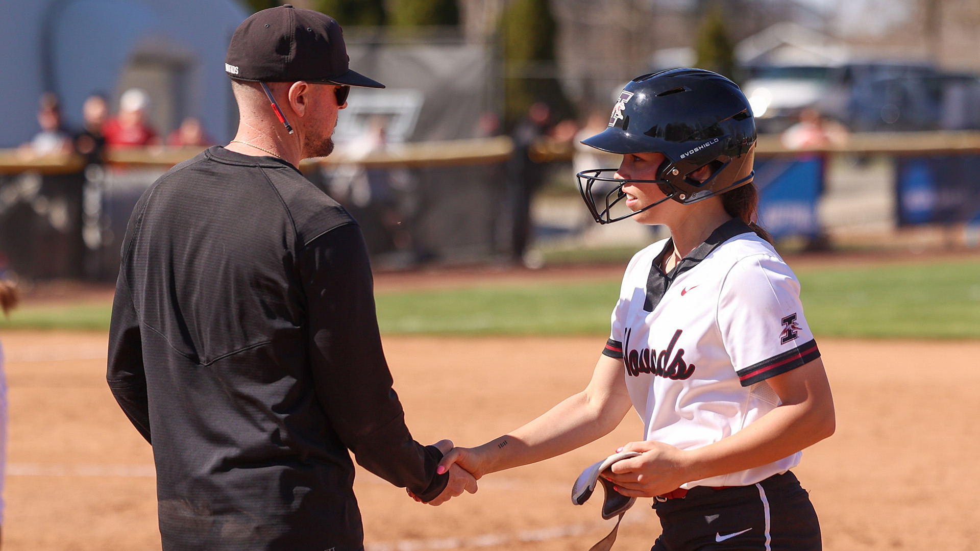 Peyton Cusack shakes the hand of first base coach Ben Ferrell.