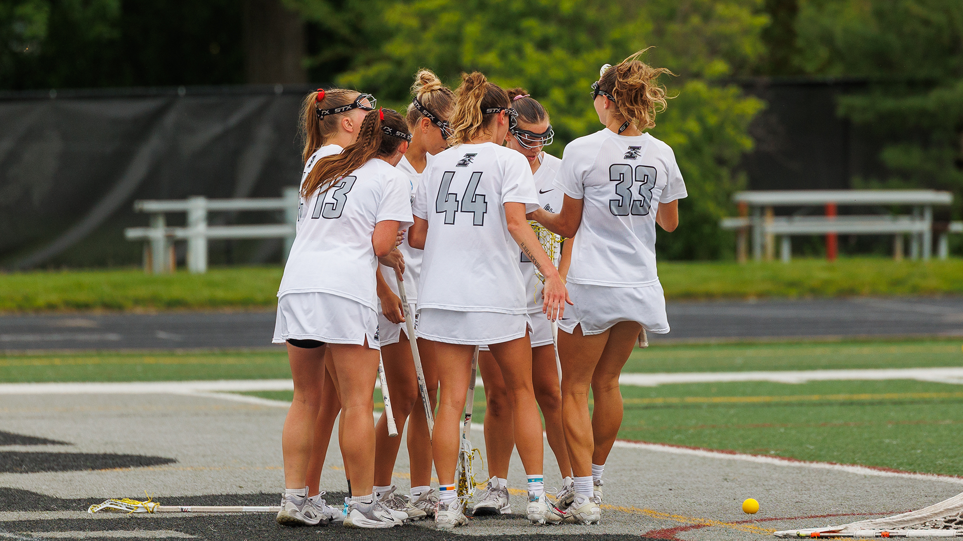 UIndy women's lacrosse team huddling 