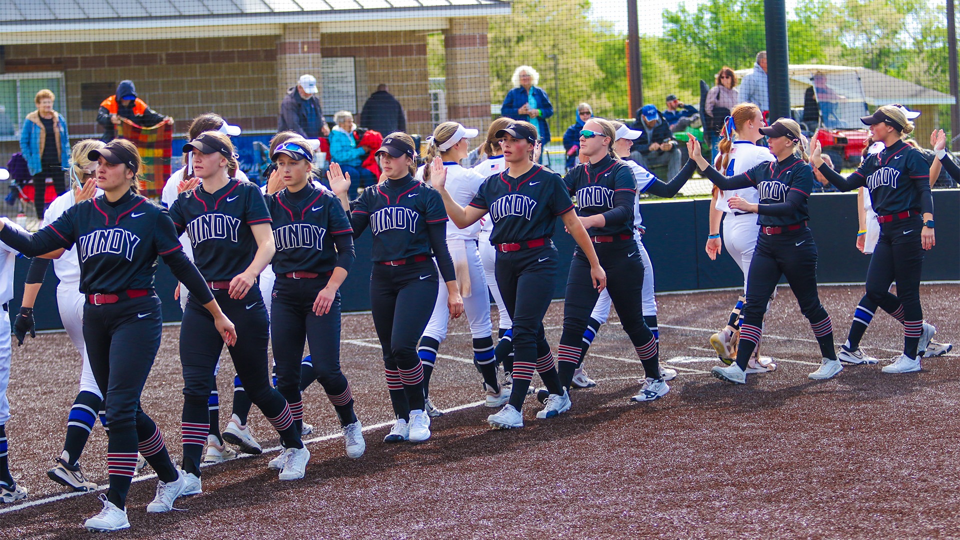 The UIndy softball team in the postgame hand-shake line with Rockhurst.