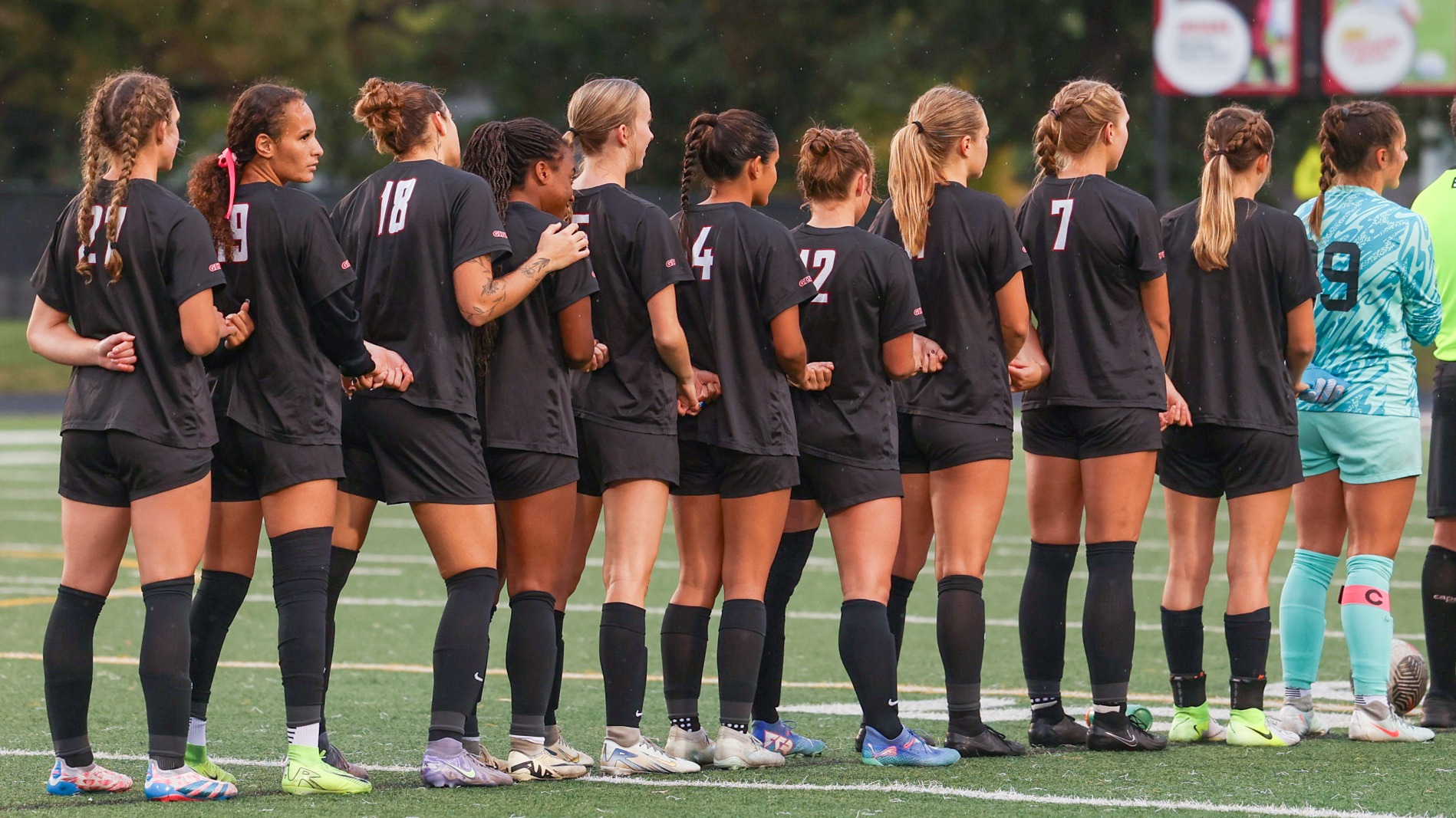 The Women's Soccer team lines up during the national anthem