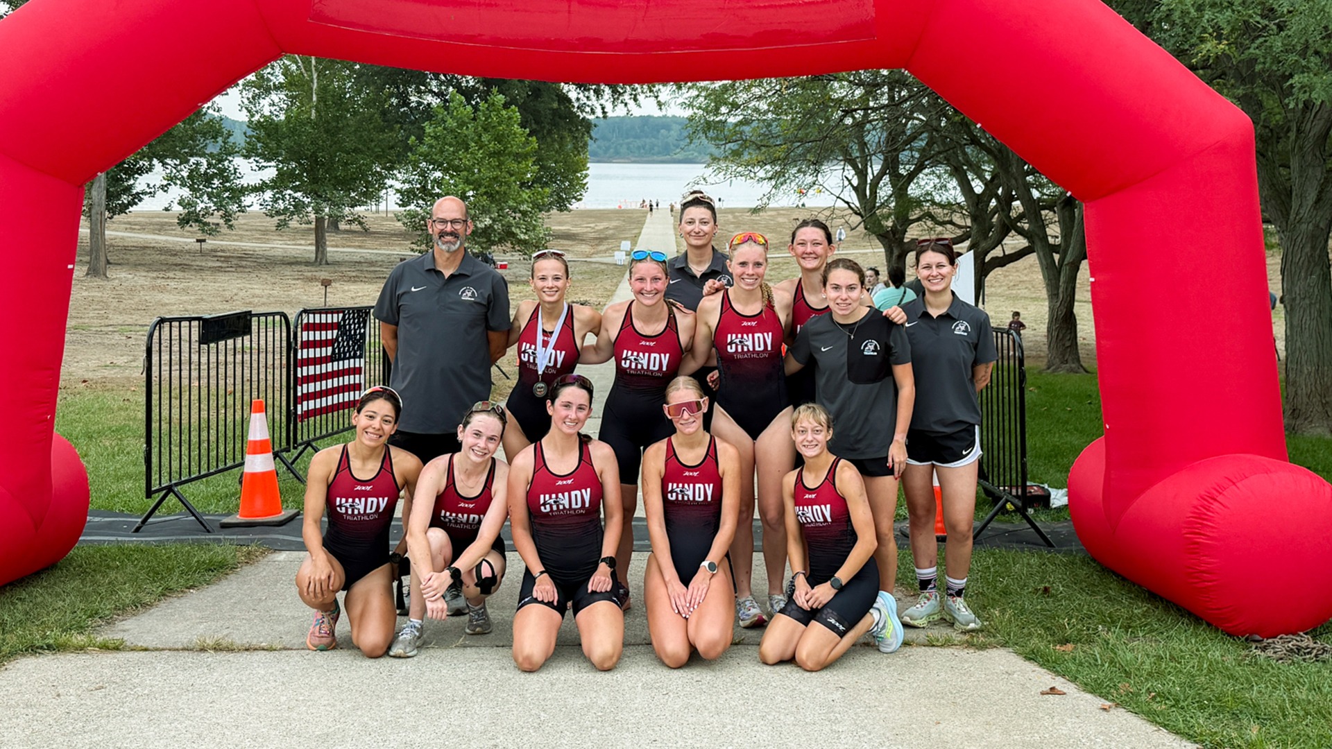 Women's Triathlon team photo at Peru race in front of water