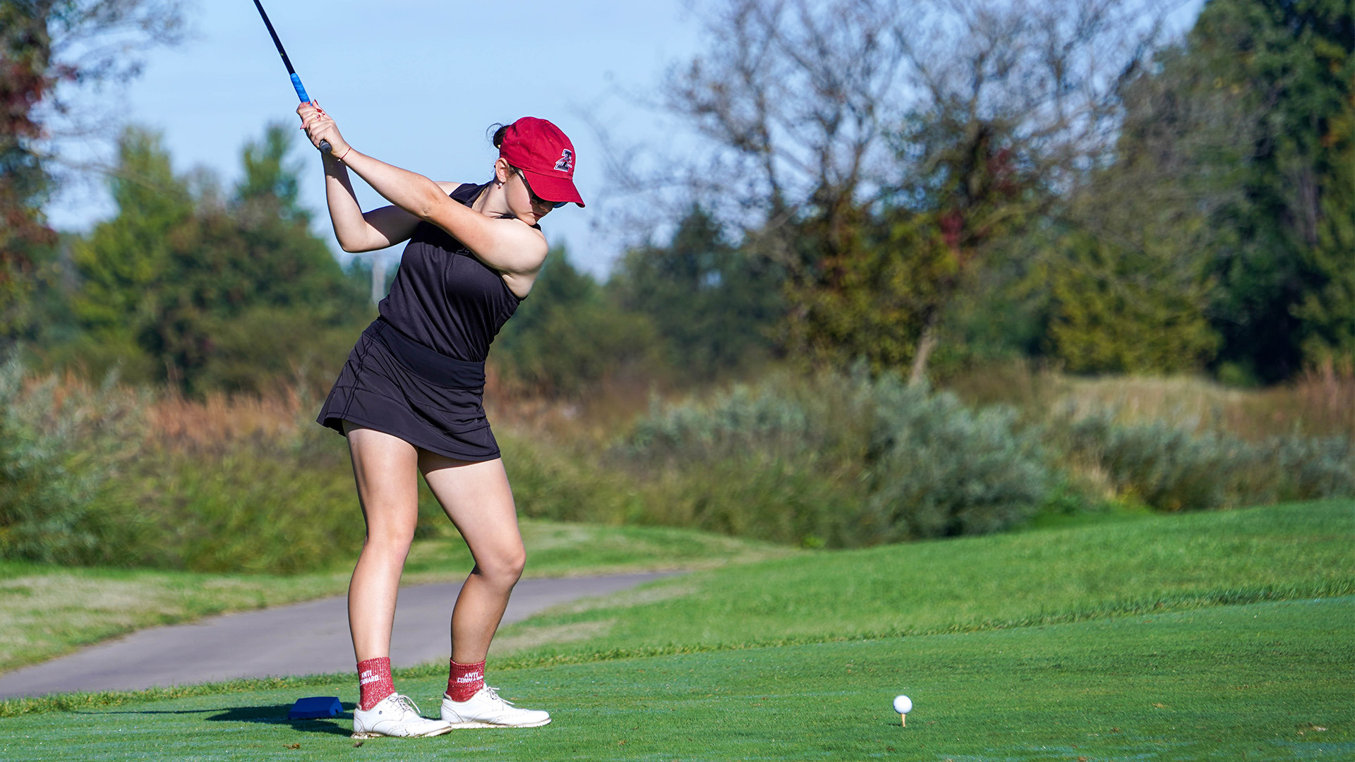 UIndy golfer Lucile Ceolin in mid back swing.