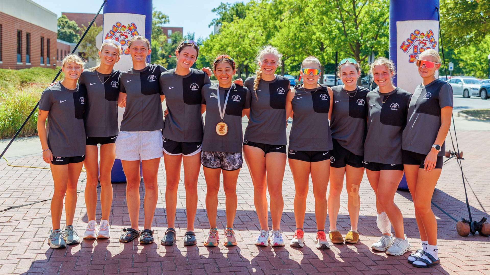 2026 triathlon team at finish line in front of Ruth Lilly