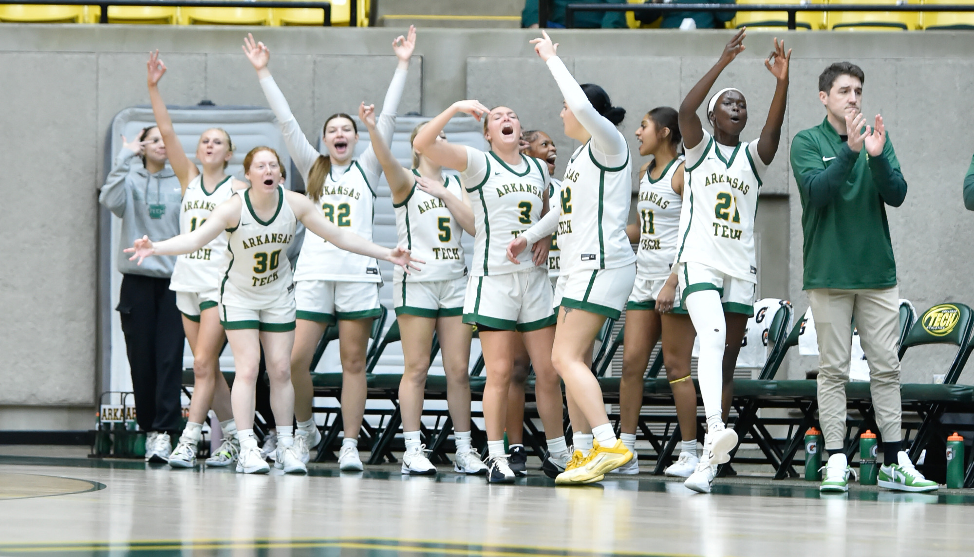 WBB bench celebtrating three-point make vs. Ouachita Baptist
