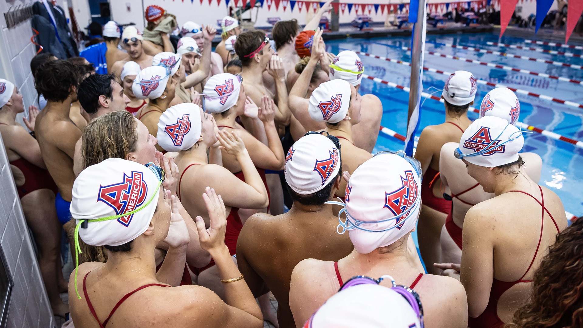 Swim and dive teams cheering at a home meet