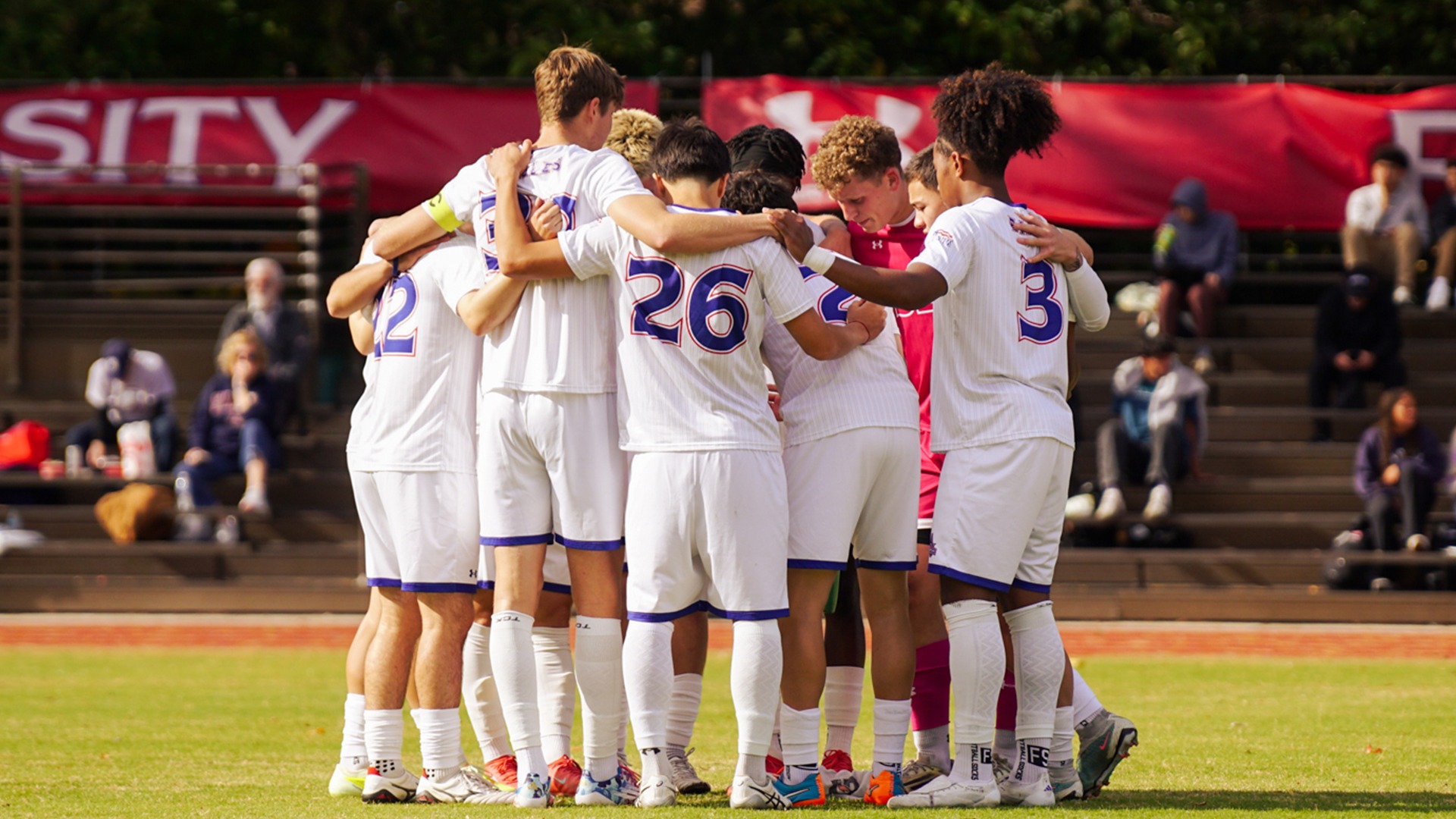 The men's soccer team in a huddle before a match.