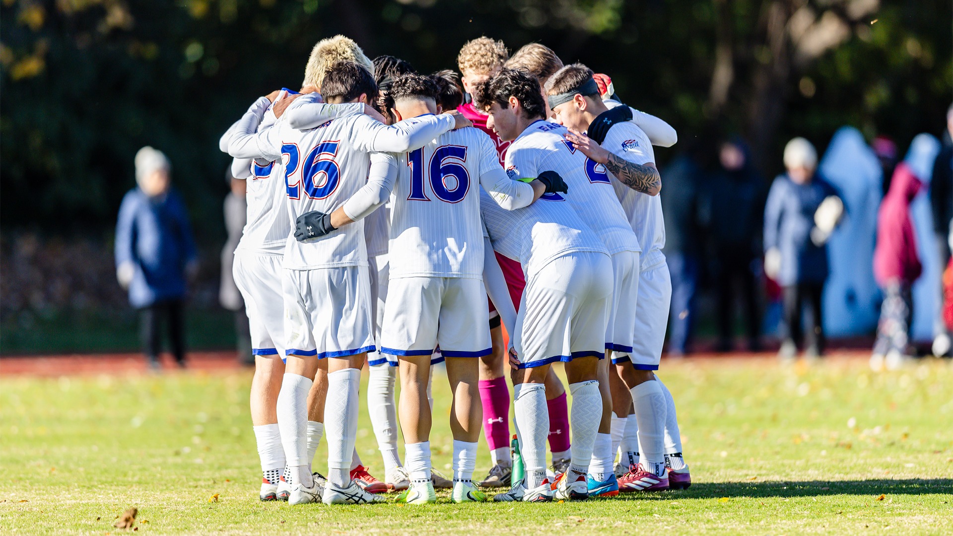 The men's soccer team huddled on the field before a match.