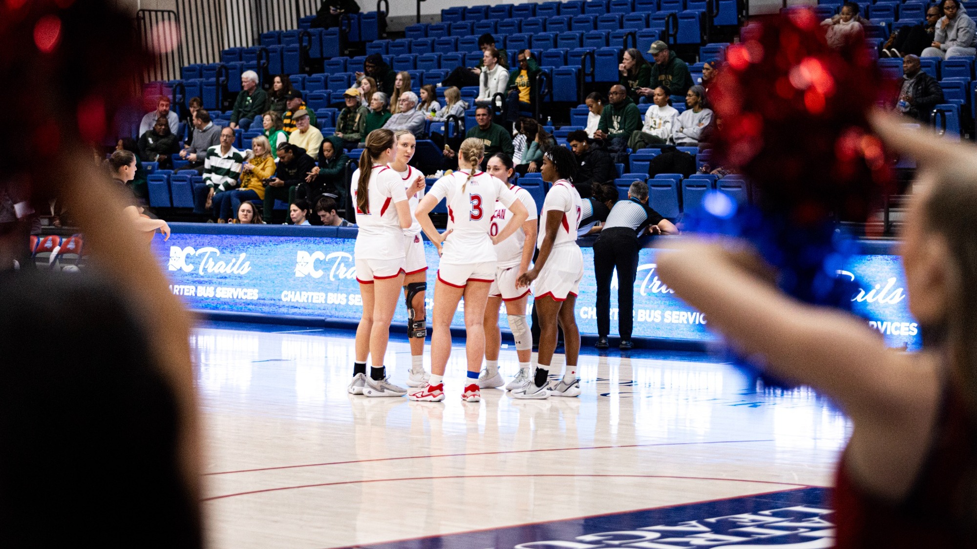 Women's Basketball huddles together on the court during a stoppage in play against William & Mary.