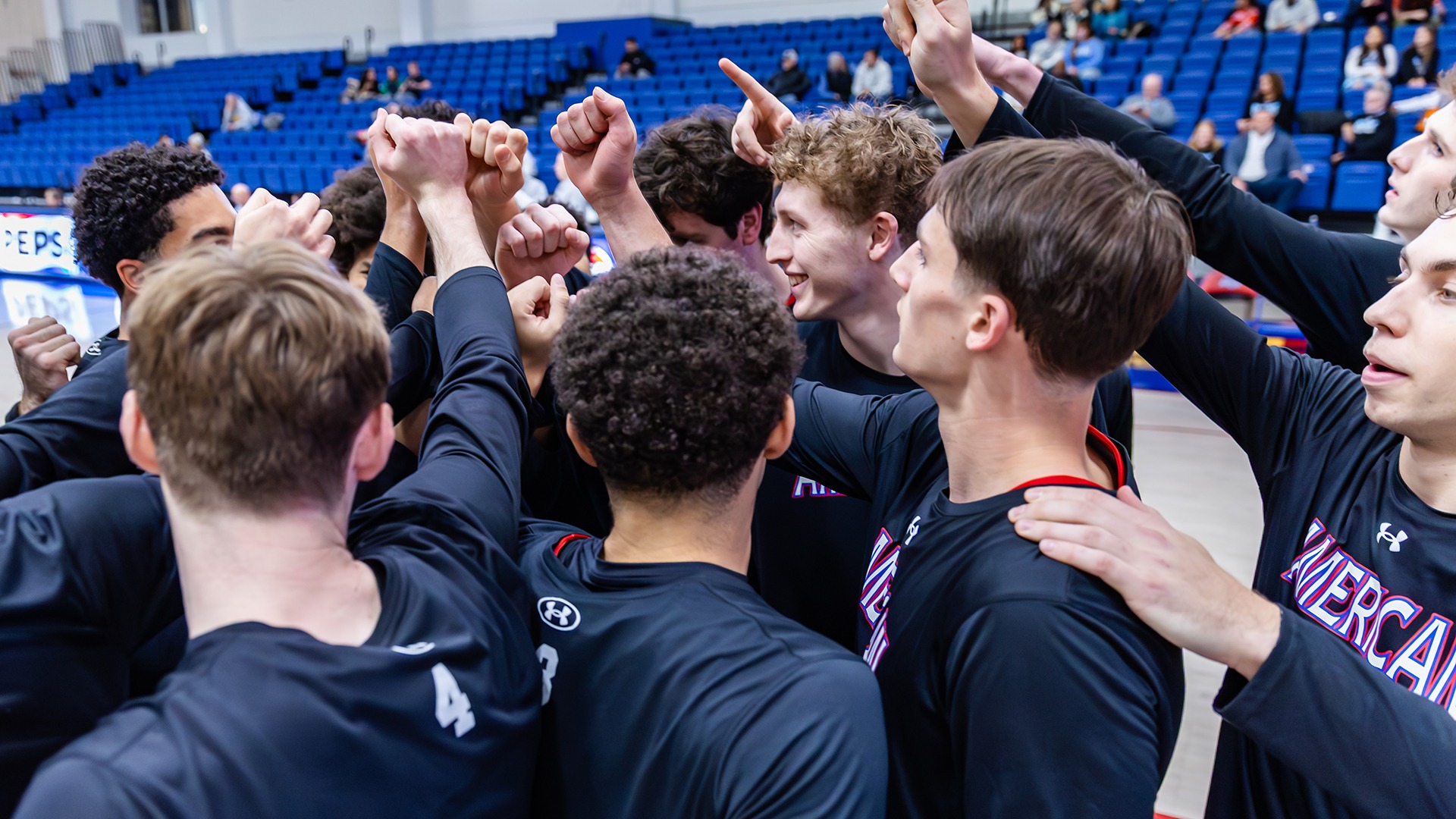 men's basketball huddle in black warm-ups